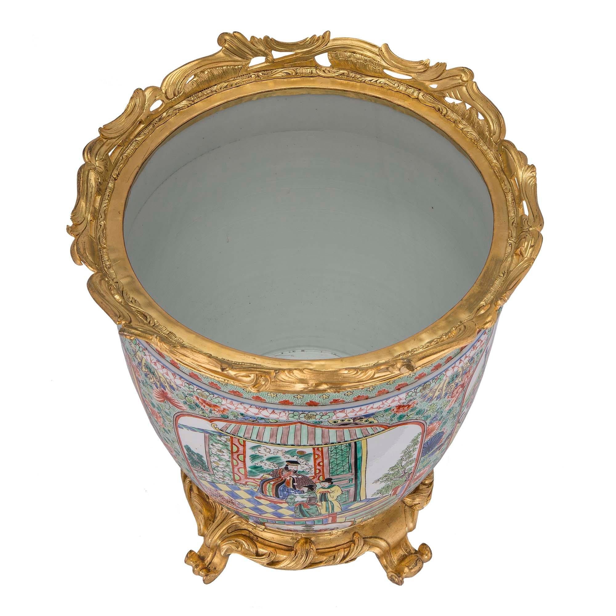 A very decorative 19th century Asian export Longuy porcelain urn with French 19th century Louis XV st. ormolu mounts. The urn is raised by scrolled ormolu feet below the finely chased ormolu base. Wonderful and richly hued handpainted hues decorate