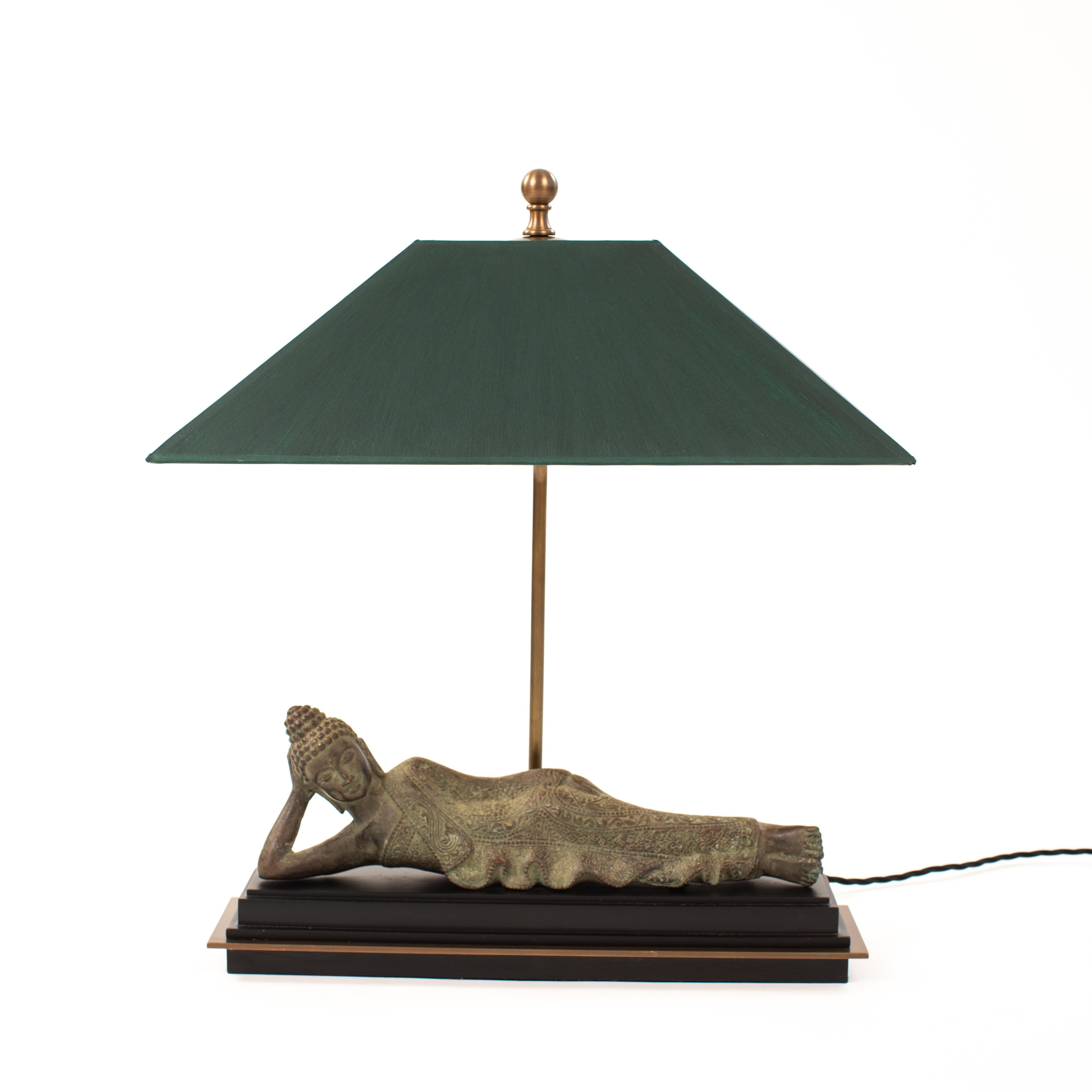 This early 20th-century Mandalay-style reclining monk, made of patinated bronze, has been transformed into a figurative table lamp.
The disciple has a peaceful face and a resting, elegant posture. His face is handsome, with a slight smile and a