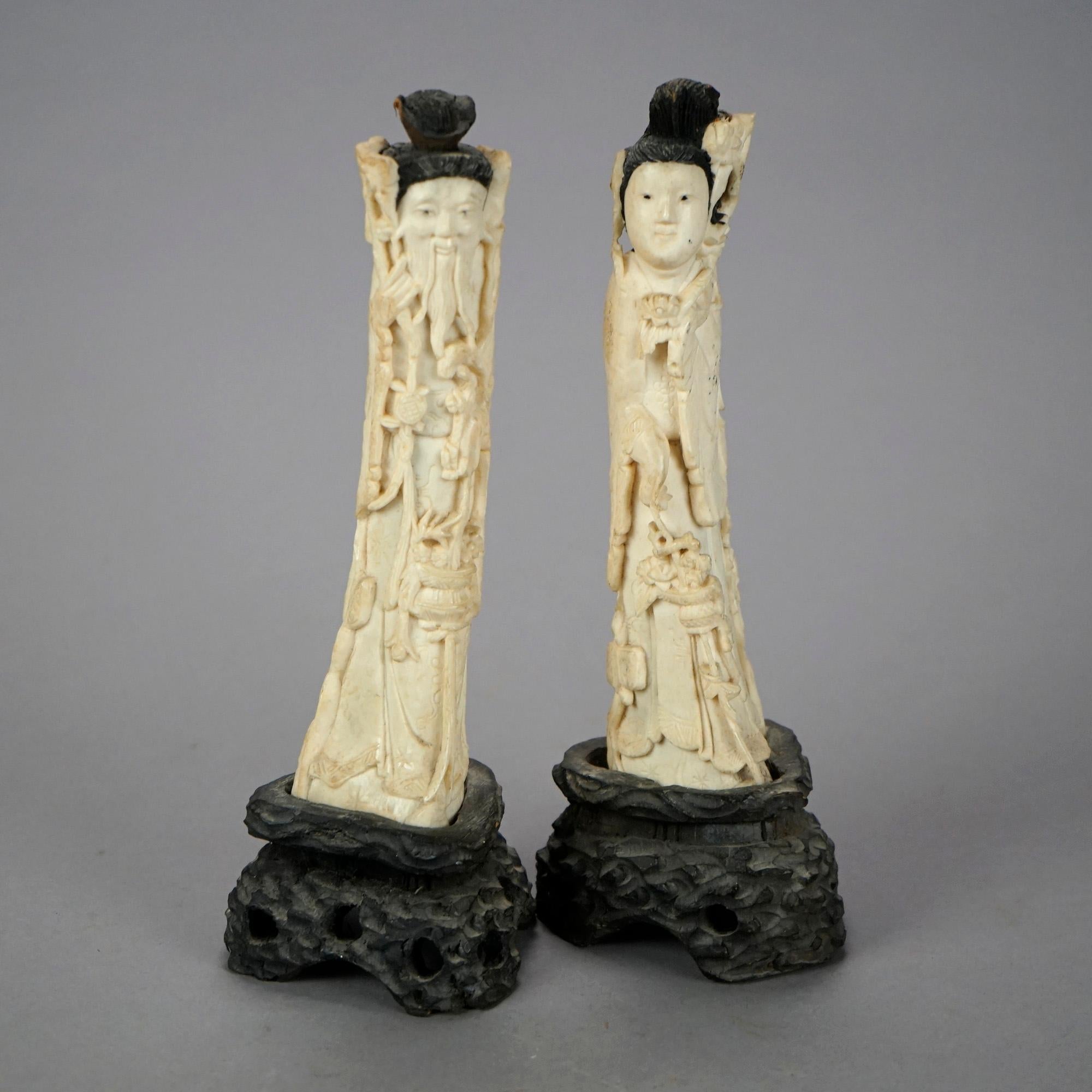 A pair of Chinese figures offer carved bone wise man and woman mounted on carved hardwood bases, 20th century

Measures- 9''H x 3.25''W x 3.25''D
