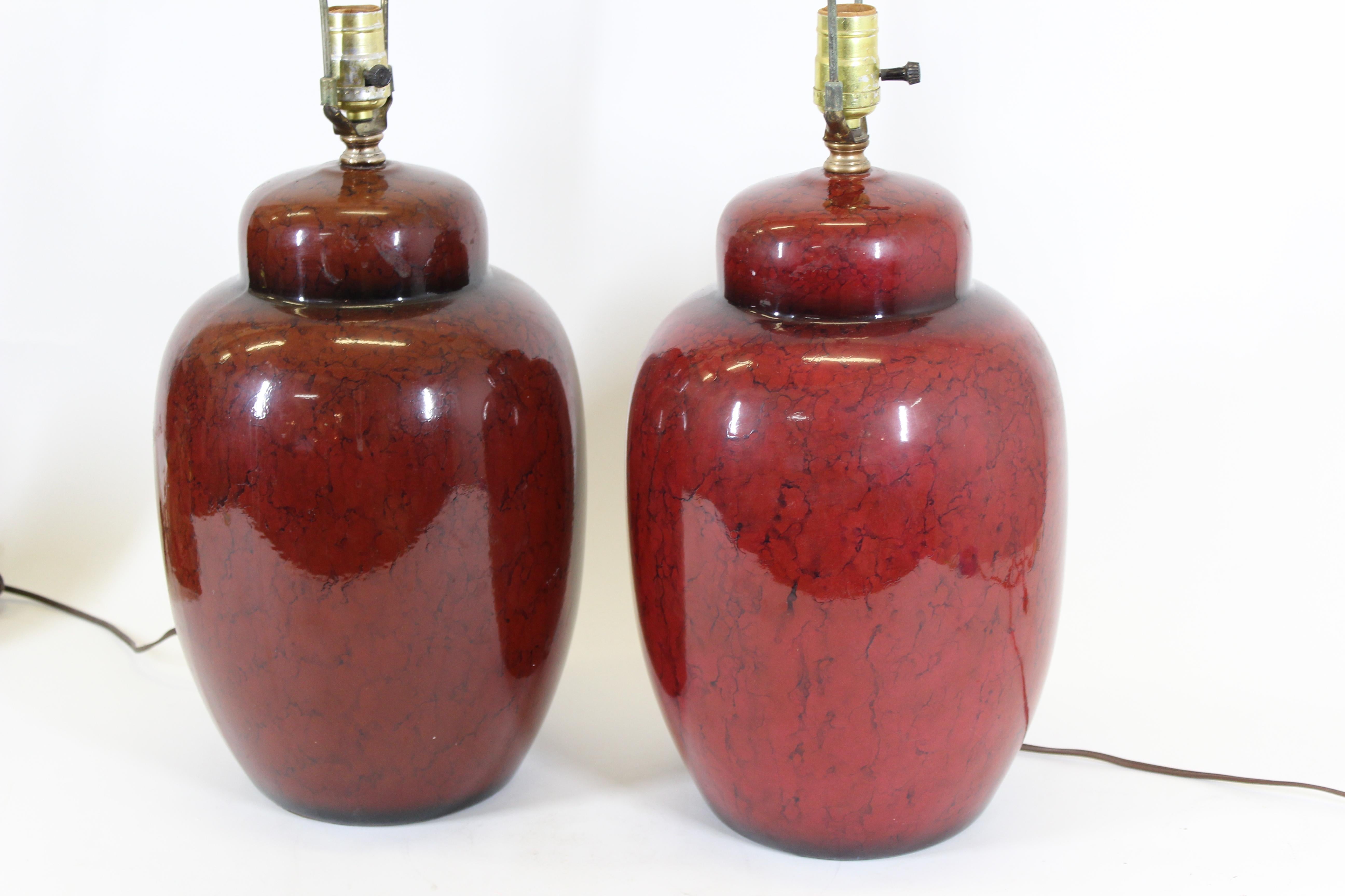 Asian ceramic table lamps in shape of ginger jars, painted in red glaze. In great vintage condition with minor age-appropriate wear.
