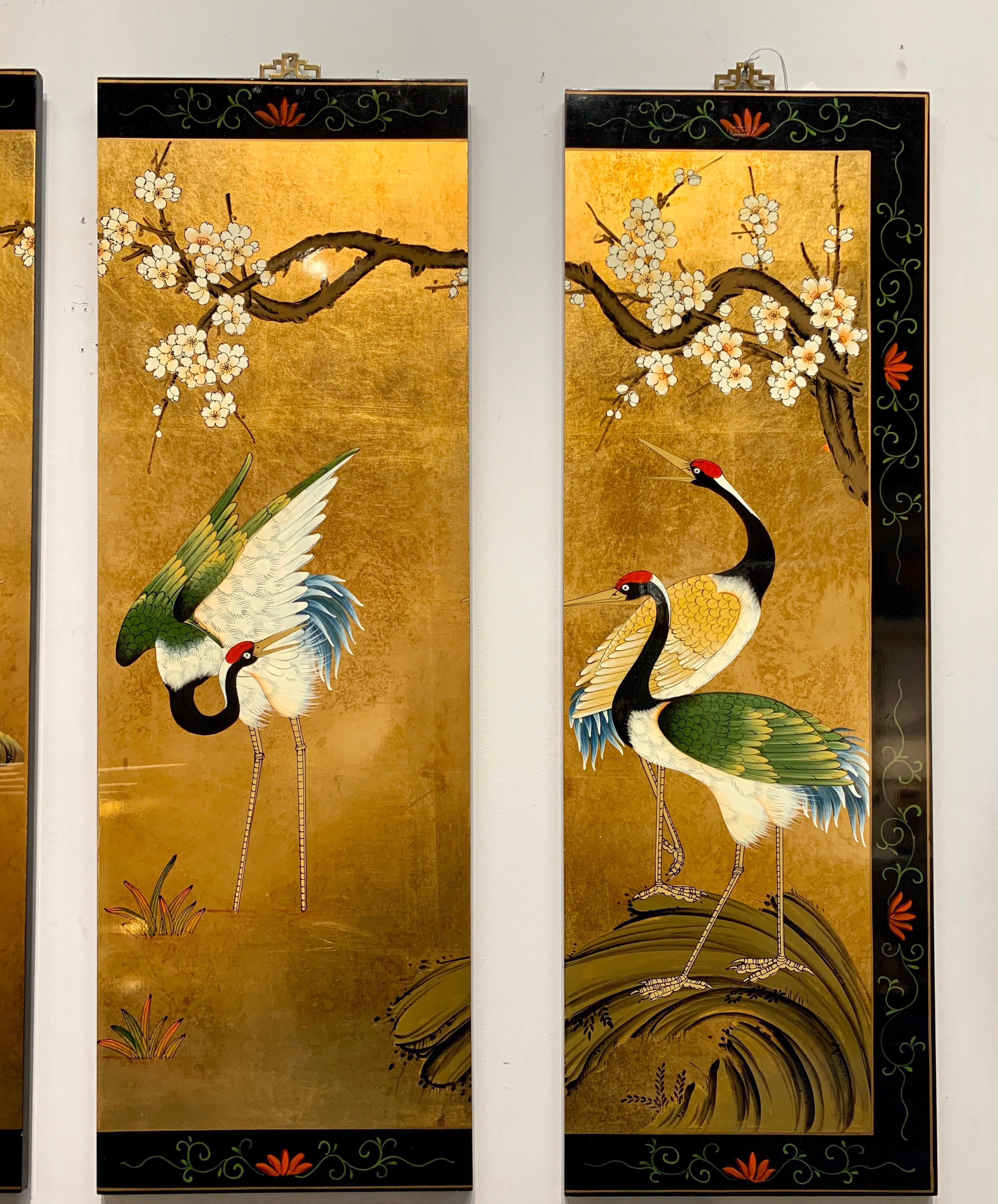 Set of four beautiful Chinese gold leaf panels with hand painted decoration depicting cranes and flowering trees. Each has brass hardware ready for hanging. Each measures 12” W x 36” H x .5” D.