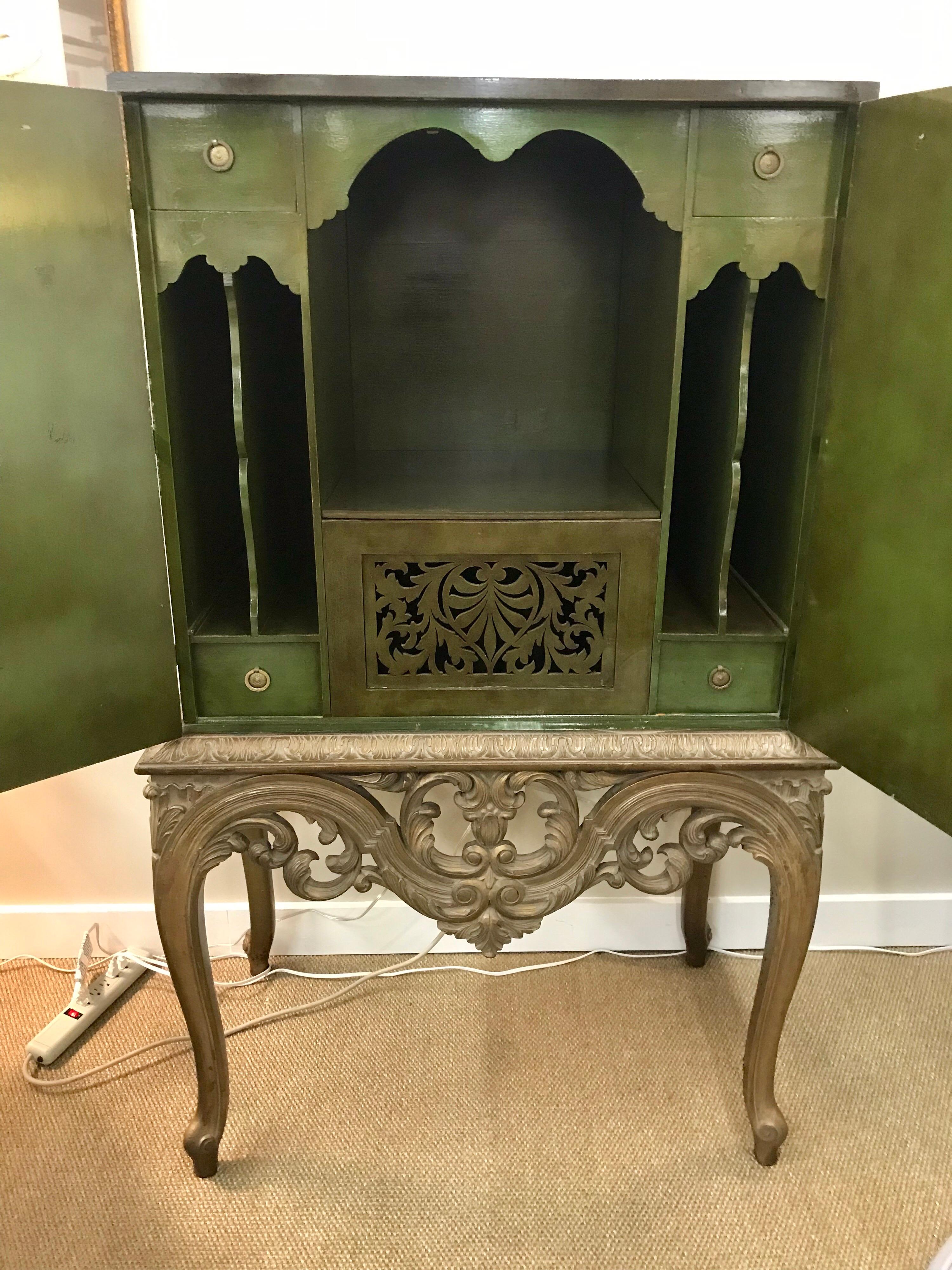 Magnificent Asian chinoiserie cabinet on carved stand. Multi-purpose usage indeed. The color green is something to behold. It is made up of two piece, a top and a bottom.