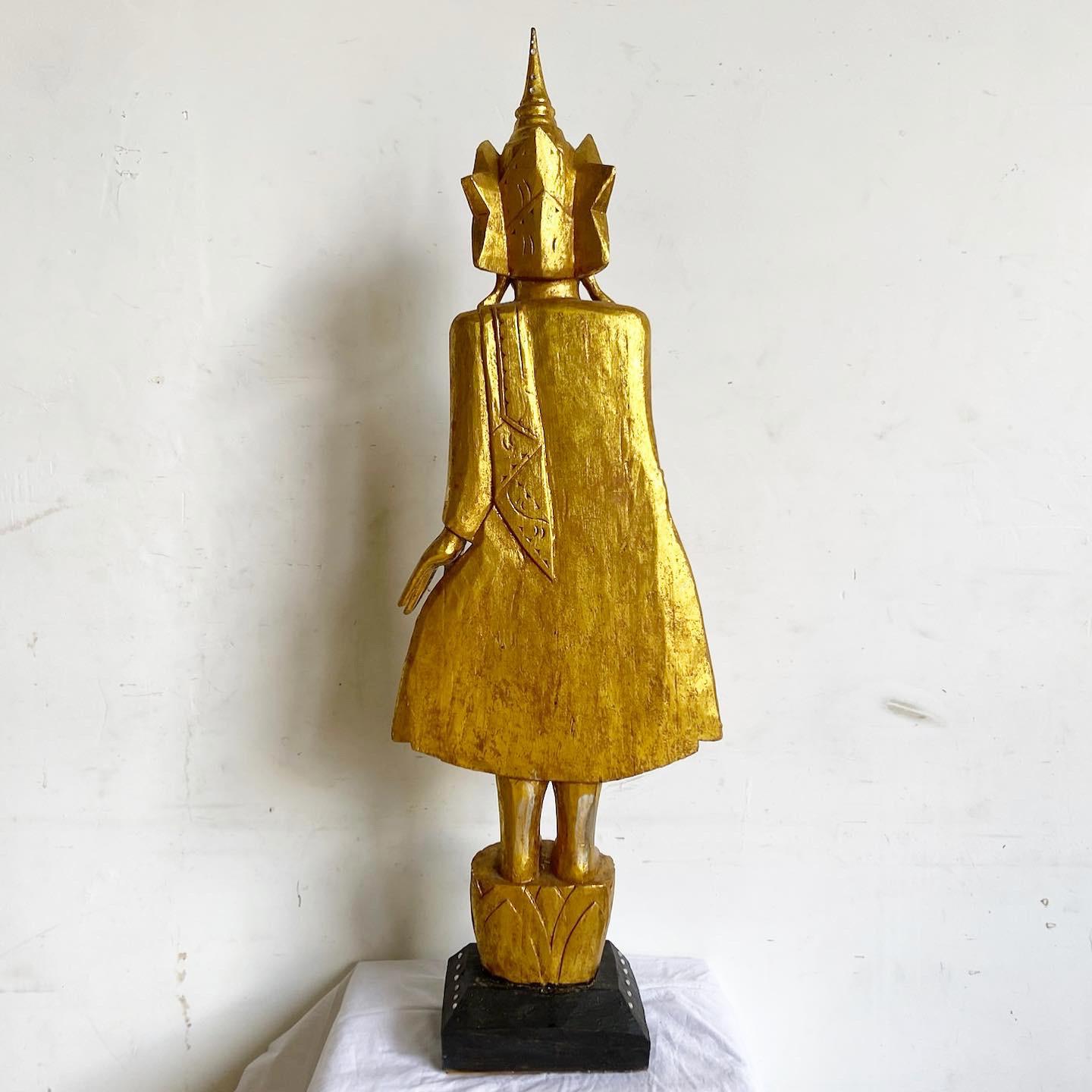 Faites l'expérience de la sérénité et de l'opulence avec cette sculpture en bois doré de Bouddha. Méticuleusement sculpté à la main, ce chef-d'œuvre asiatique est orné d'une finition dorée rayonnante, capturant l'essence de la tranquillité de