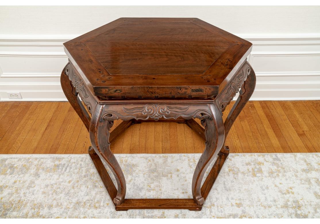 Asian hand carved hexagonal center table distinguished by geometric forms and clean graceful lines featuring picture framed top with carved apron on elegant cabriole legs connected with a hexagonal base that echoes the top. 
Measures: 37