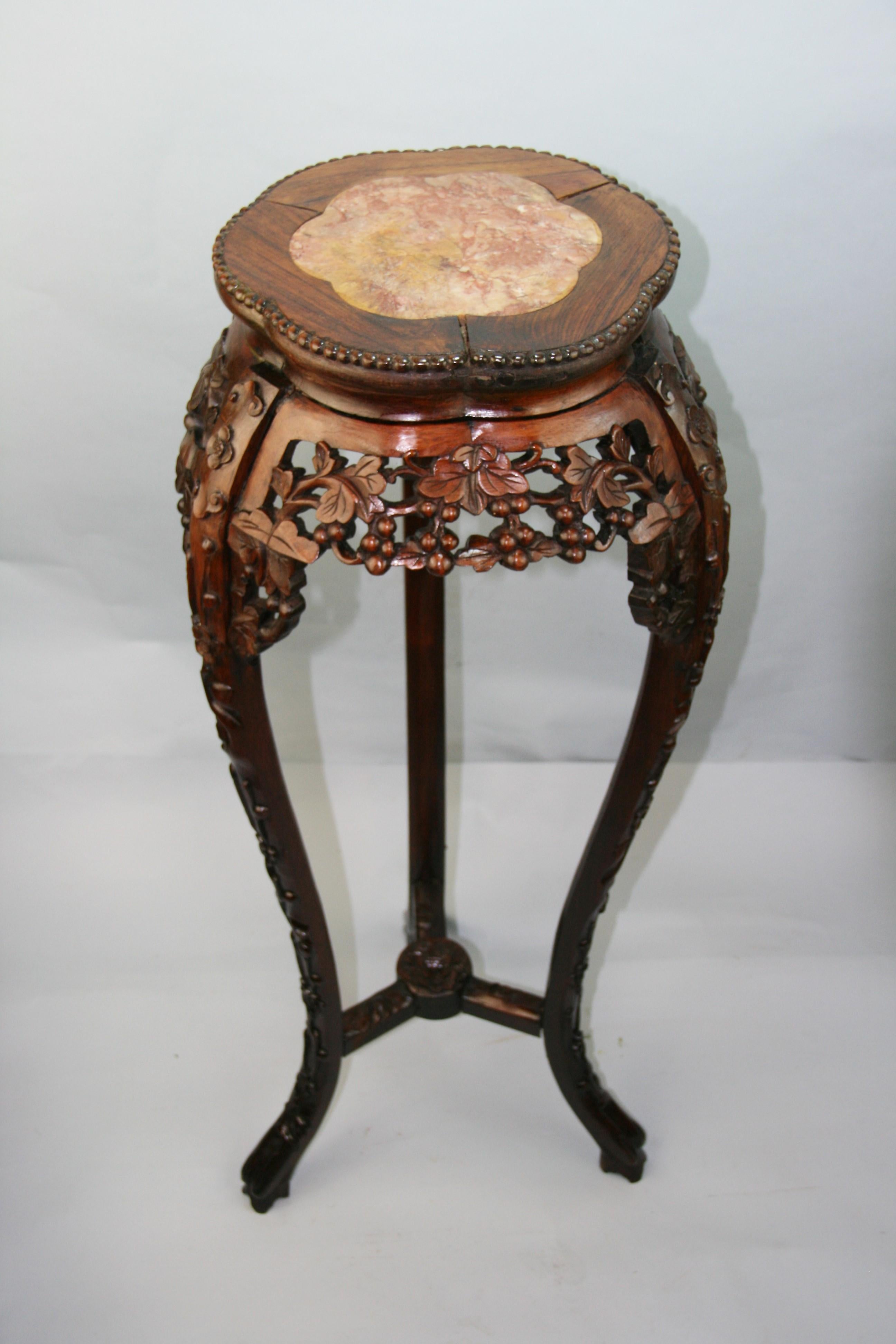 Hand carved rosewood pedestal with inlaid marble. The frieze and apron are carved in leaf and floral motifs as are the legs and cross stretchers.
