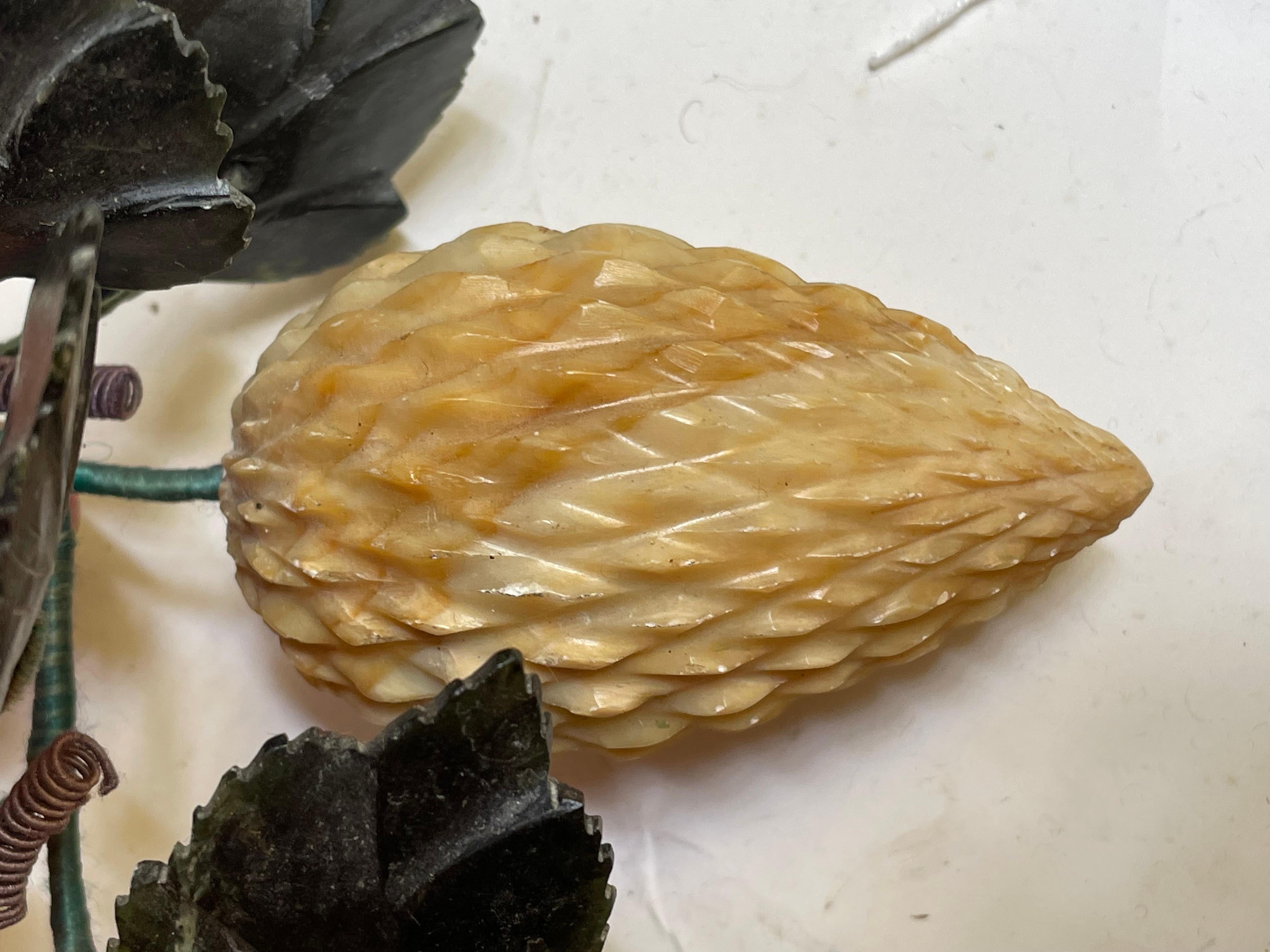 Se trata de una fruta de forma interesante, de color amarillo abigarrado, con puntas talladas y hojas de jade verde muy bien talladas, pero desconozco el nombre de la fruta. Los tallos son de alambre verde envuelto con alambre verde y marrón