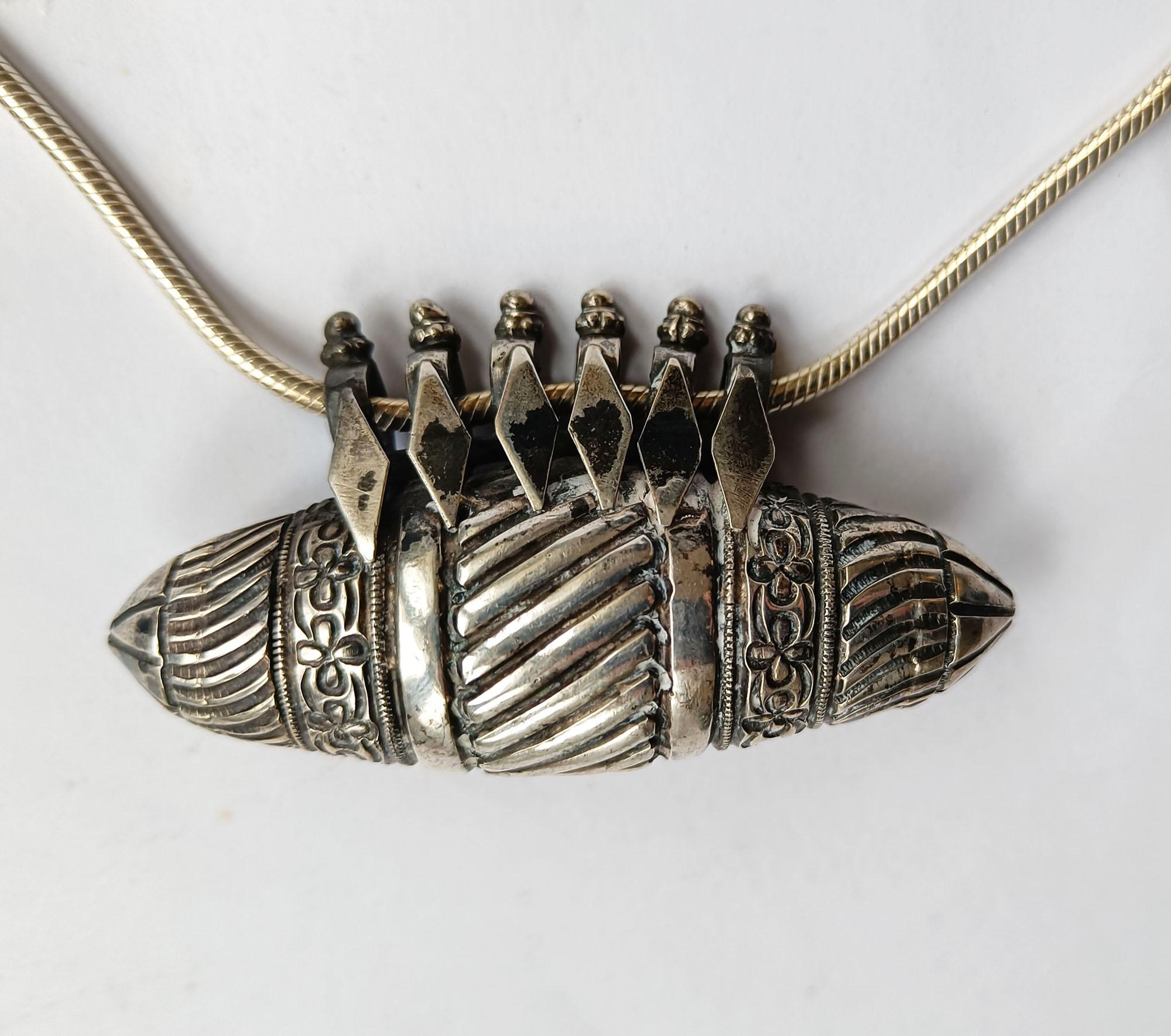  
Indian Hindu Silver Amulet necklace 
Heavy bullet shaped Amulet  necklace with pointed ends with floral and geometric design
High grade silver  
Pendant Length 9  cm  weight 90 grams
Period mid 20th century
Condition: Fine.