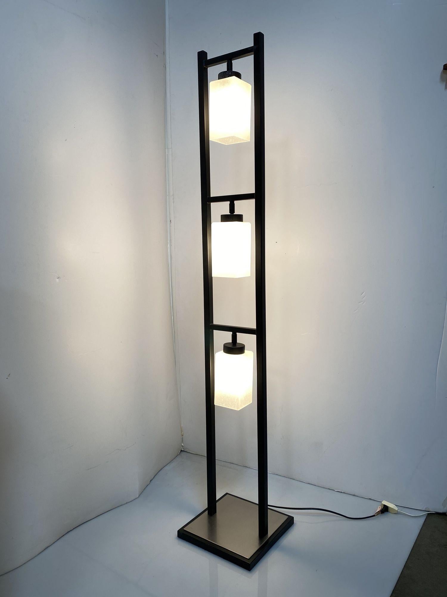 Lámpara de pie de 3 luces de metal negro pesado, de diseño minimalista y moderno, con una placa de suelo de acero inoxidable y pantallas cuadradas cubistas de cristal de leche.
Alrededor de 1990, EEUU.
