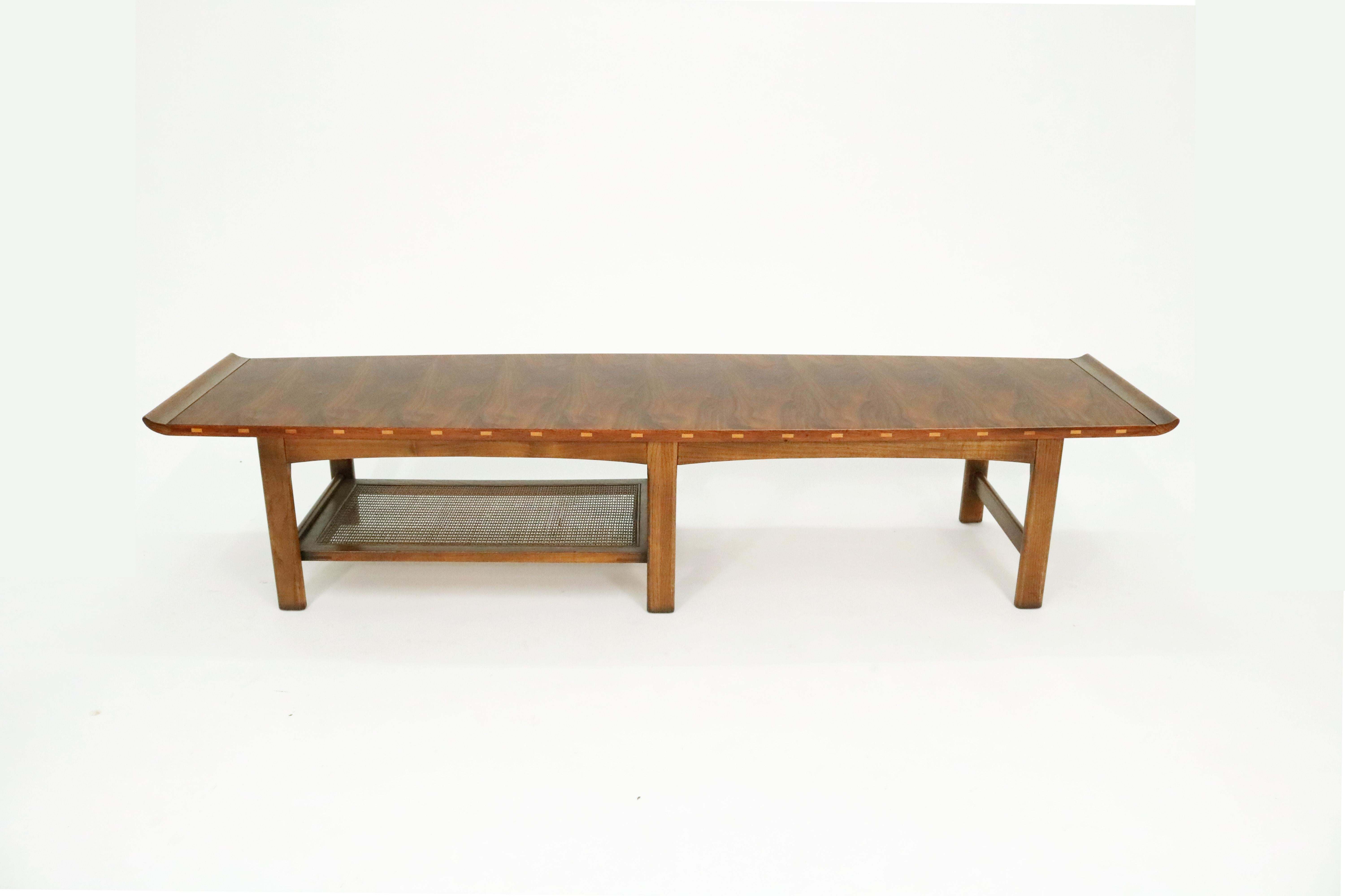 1965 Asian-inspired 'Vogue' walnut coffee table by Lane Furniture Co.

One of the most rare Mid-Century living room table lines produced by Lane, with distinctive inlaid edge accents, a cane magazine shelf, upturned ends, and a remarkably