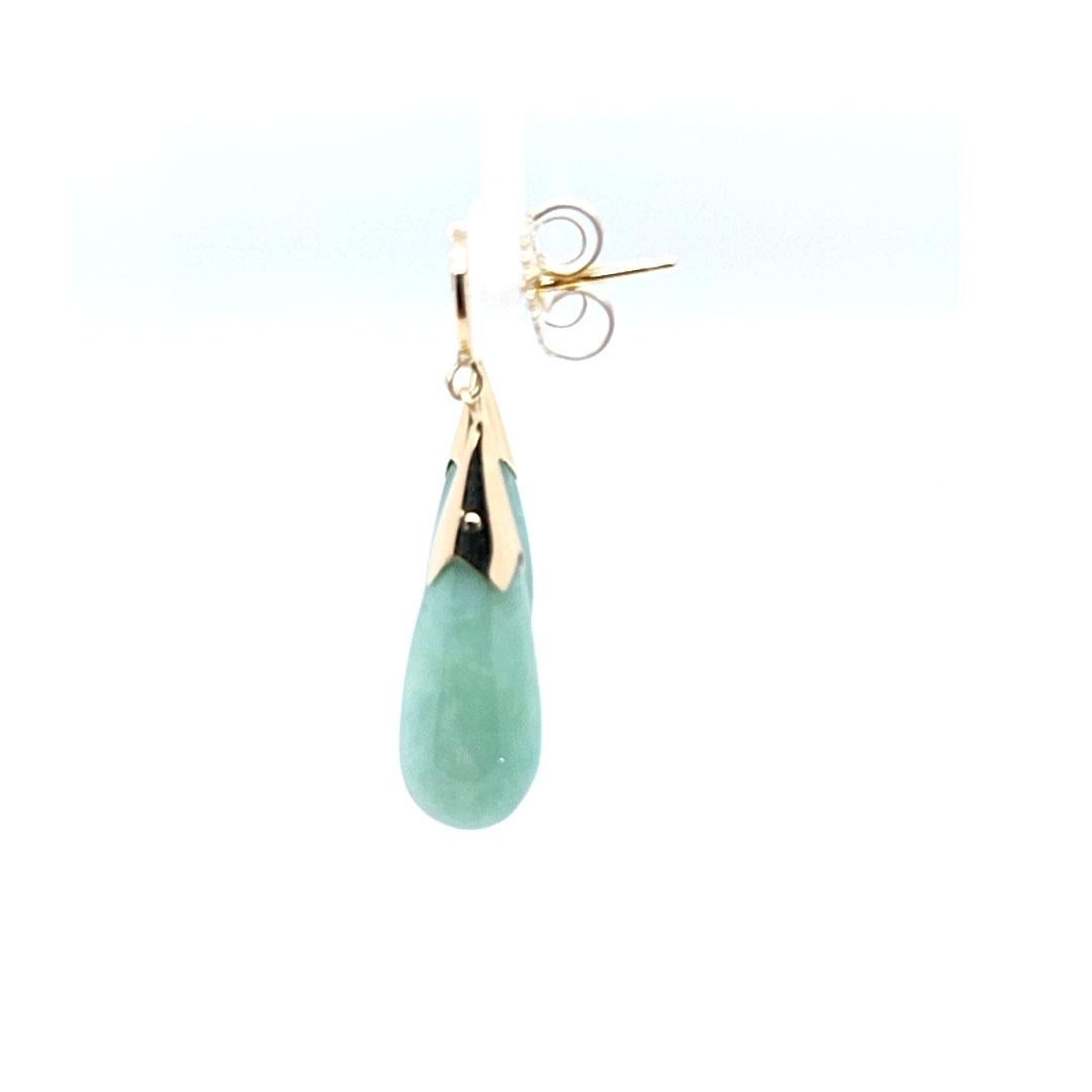 14 Karat Yellow Gold Asian Drop Earrings Featuring Carved Jade. 1.5 Inches Long. Pierced Post with Friction Back. Finished Weight is 4.5 Grams.