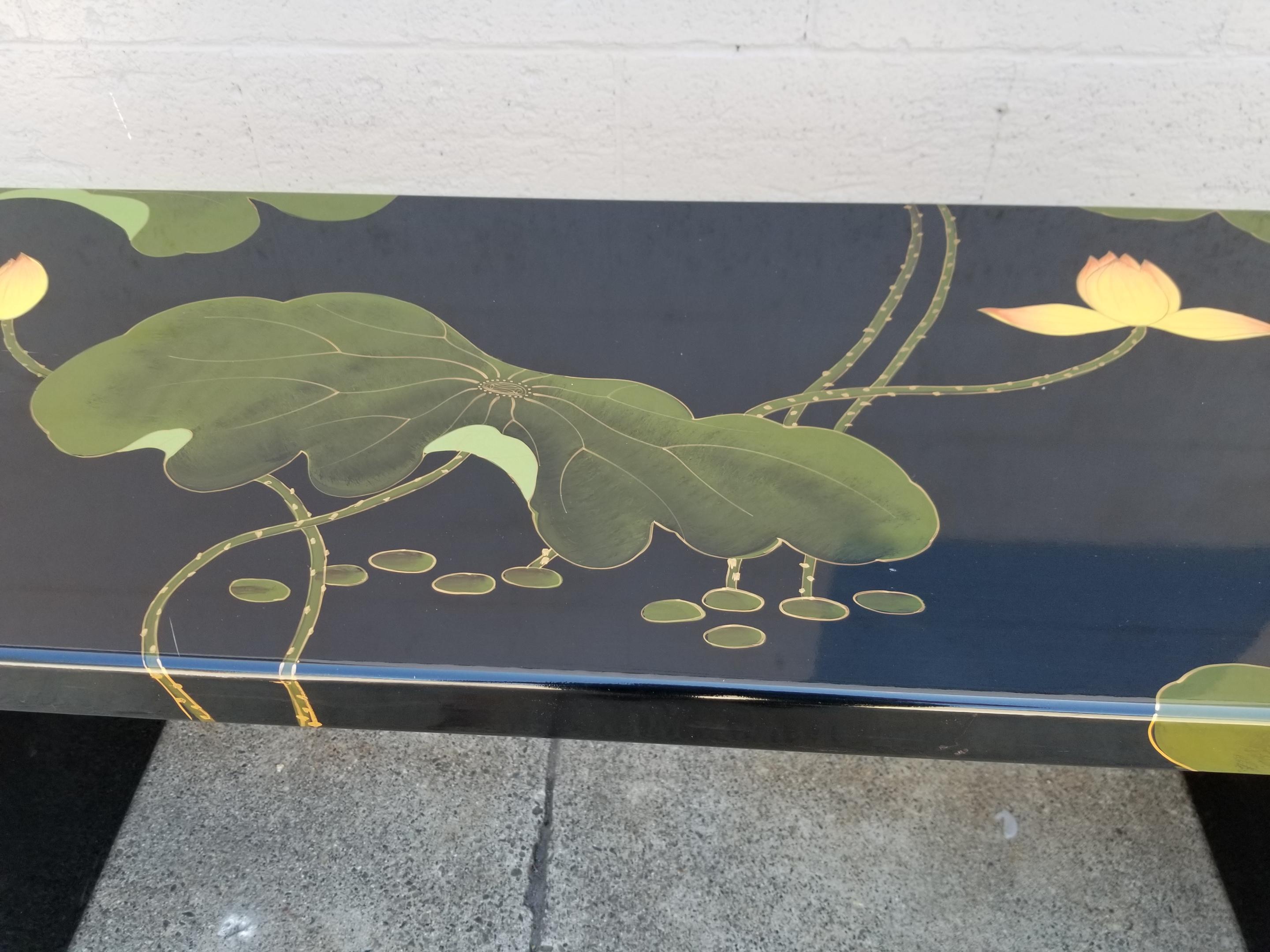 A mid to late 20th century Asian lacquered console table with lily pad flora. Bold contrasting color palate with black, green and yellow. Please check our postings for a pair of accompanying pedestals / stools.