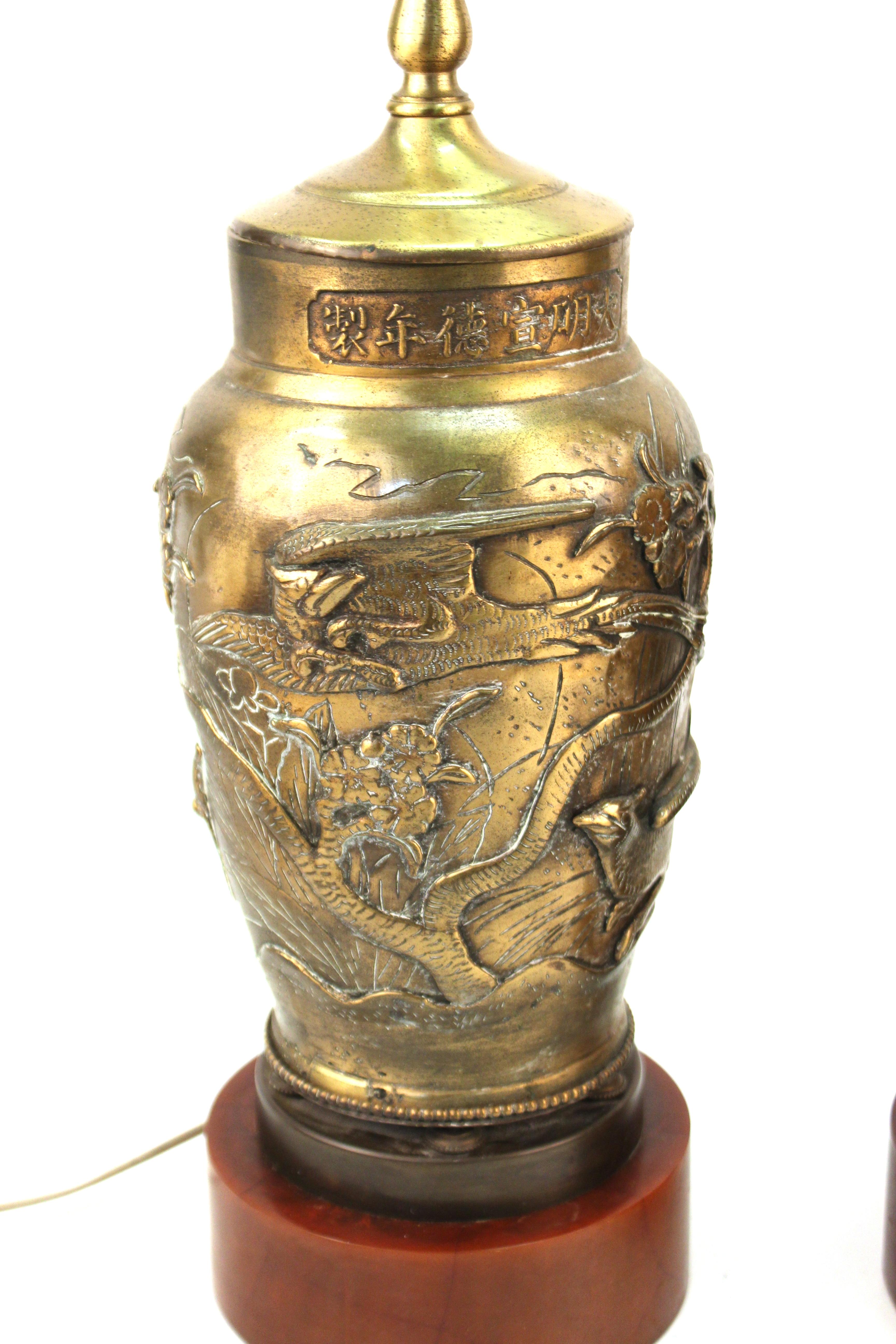 Asian Meiji style pair of brass vases with cylindrical Bakelite bases, turned into table lamps. The pair has bas-relief bird’s motif scenes. In great vintage condition with age-appropriate wear and use.

These vases are made in Japan,  in the 1920s.