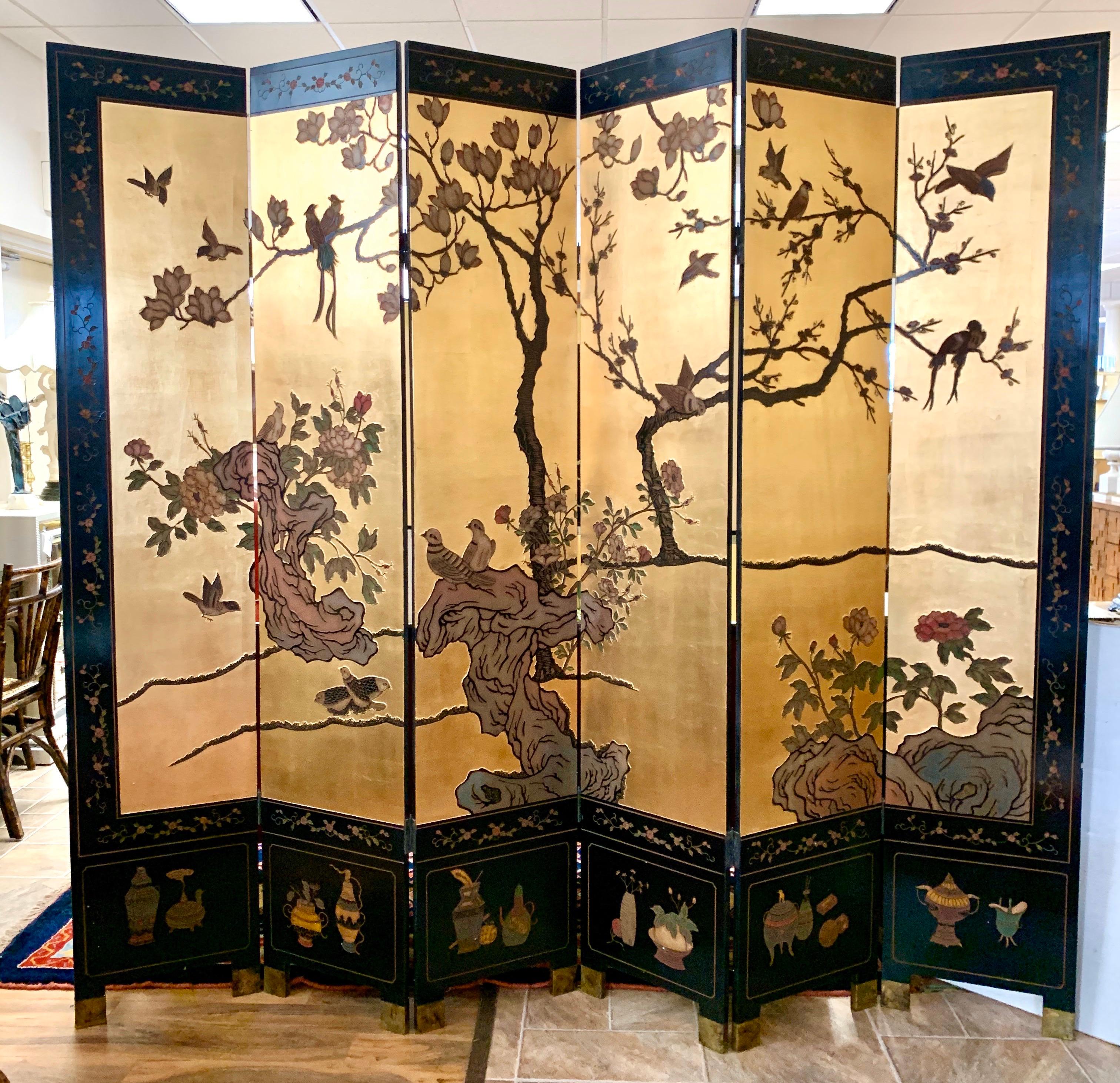 Stunning six-panel midcentury gold leaf expandable screen that measures seven feet tall
and expands up to eight feet when full opened. Magnificent gold leaf throughout. The hand carvings are impressive and the brass footings compliment the screen.
