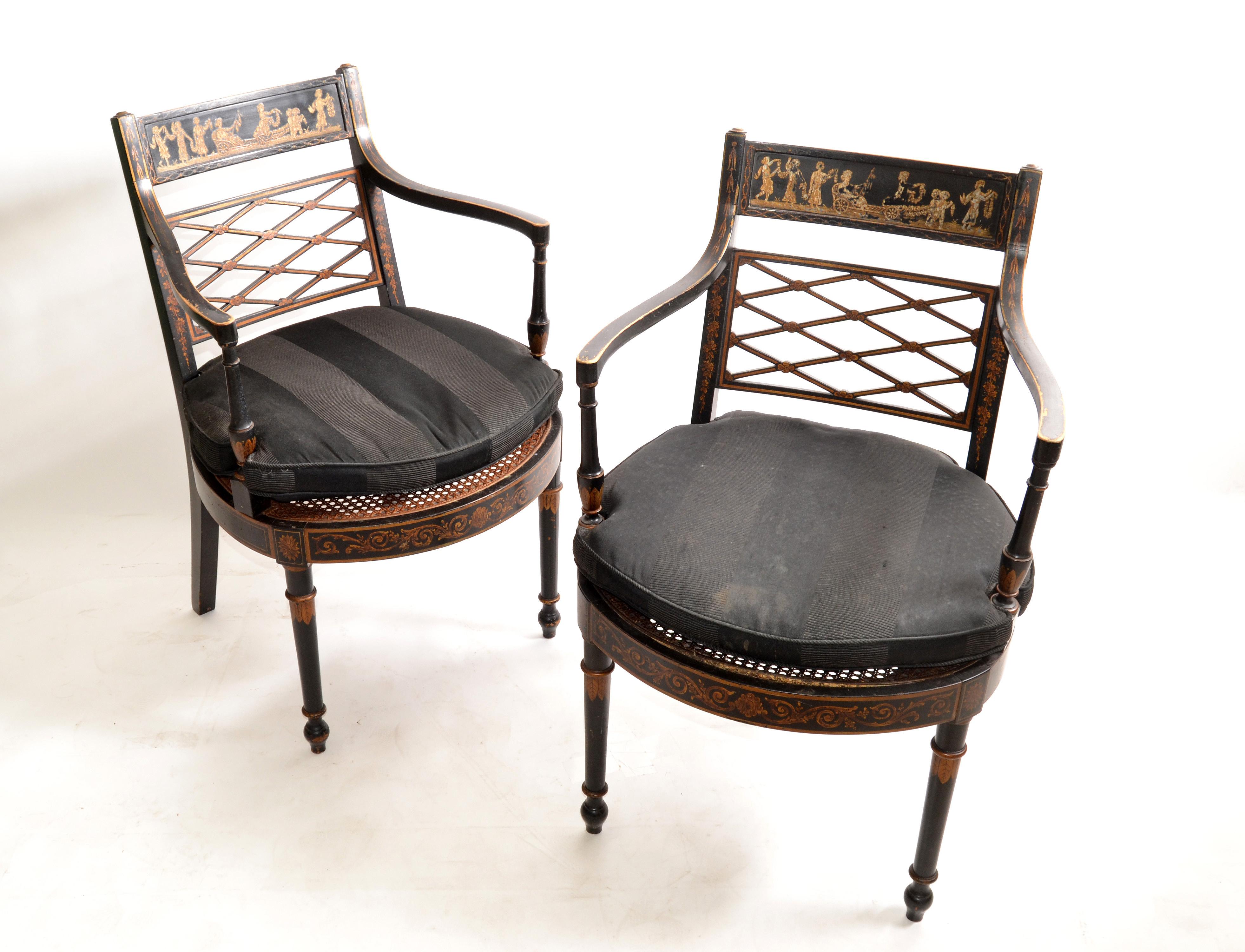Late 19th century one of a kind pair of chinoiserie antique armchairs black lacquered & gold finish with hand woven cane seats. The Backrest is thick Gilt finish depicting a travel scene. 
We have the original form fit seat cushions but recommend