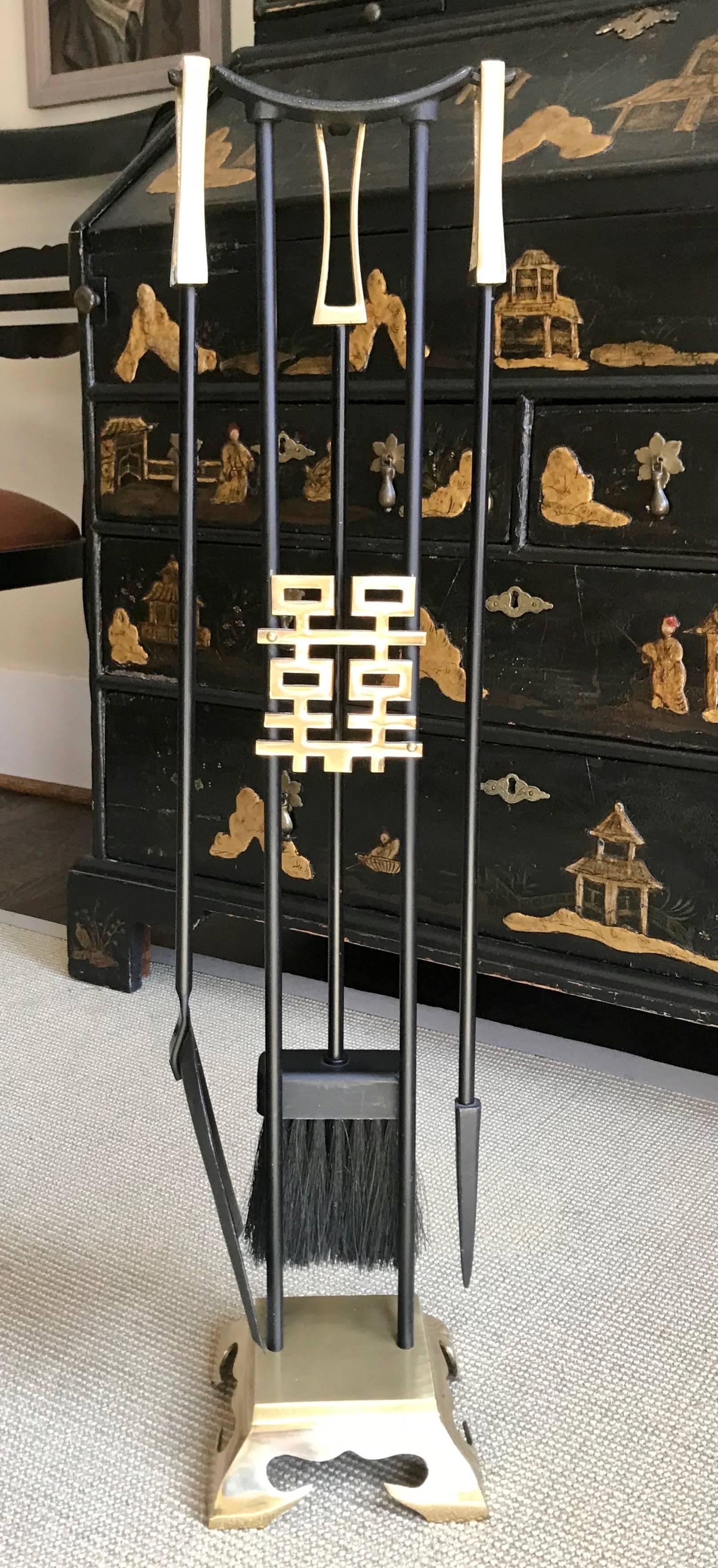 Set of fireplace tools in Asian Modern style crafted from brass and black painted iron or steel. Set includes three tools and the Stand.

Measures: 6.5