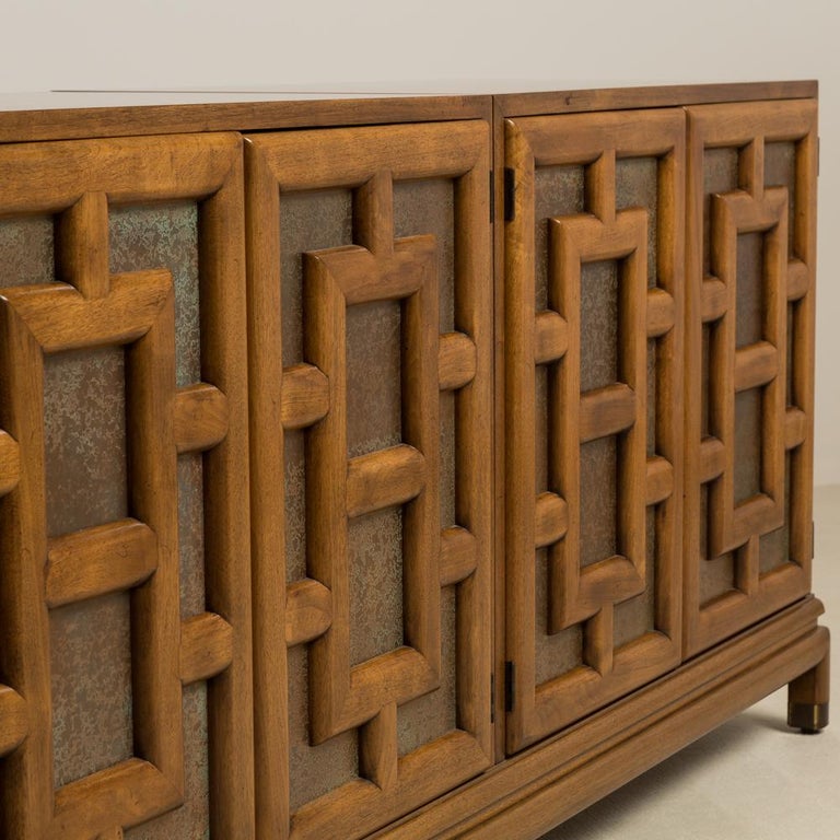 An Asian modern four door cabinet designed by Renzo Rutilil for Johnson Furniture Co. with fretwork style panelling with acid etch metalwork 1960s.
 