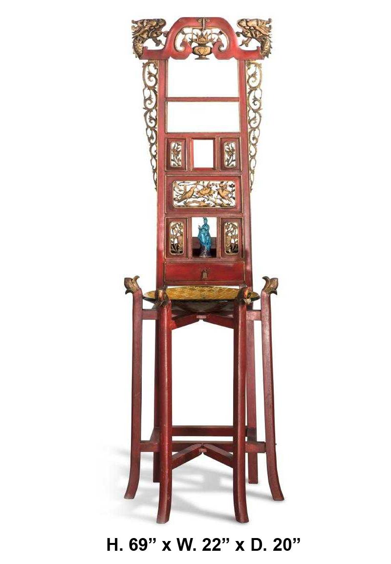 Lovely Asian parcel gilt and red painted carved stand cabinet
mid-20th century.

Surmounted with two parcel gilt dragon's heads centered by a carved foliate urn, above a blue Quan Yin figure and a key dish, supported by six sabre legs conjoined