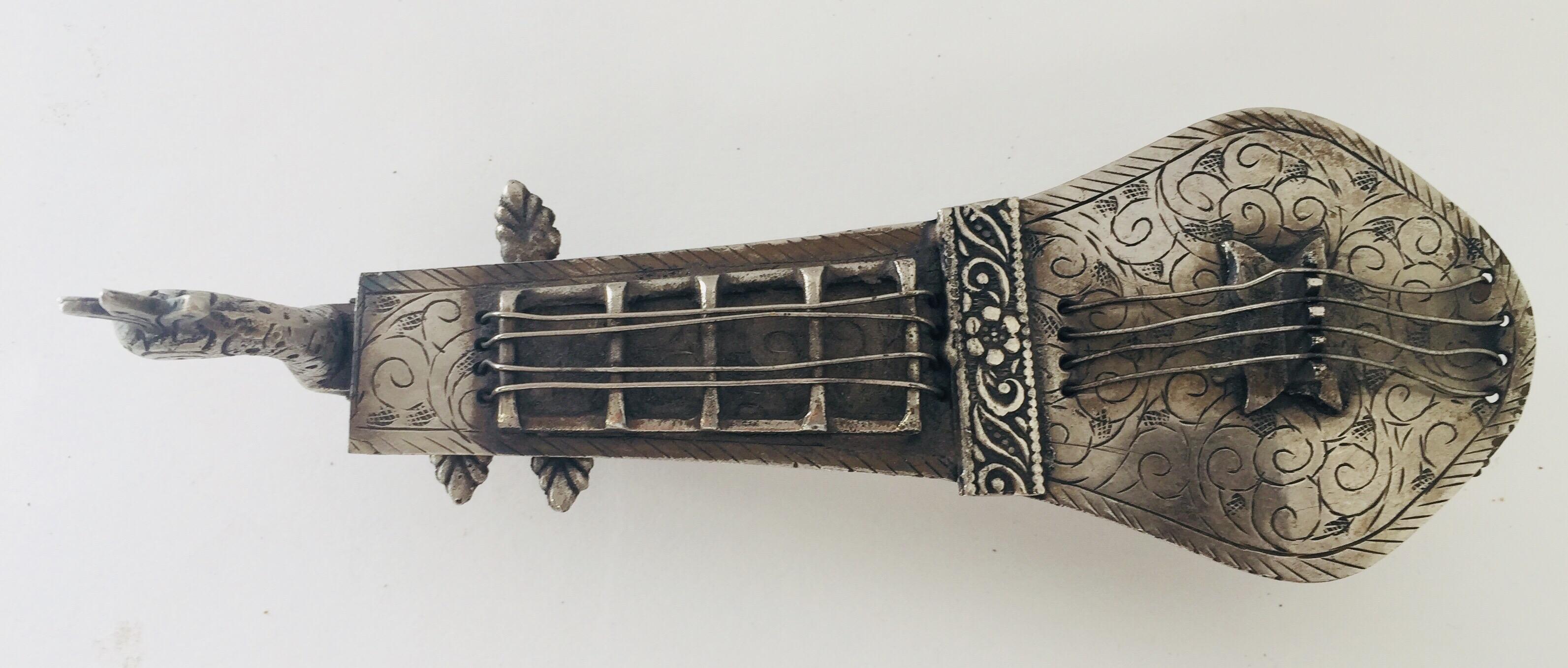 Porte-pipe à opium asiatique avec un motif de tête de paon en filigrane et en forme d'instrument à cordes indien Veena.
Alliage métallique argenté, patiné ouvert pour contenir la pipe.
Porte-pipe à opium décoratif de collection, très beau travail