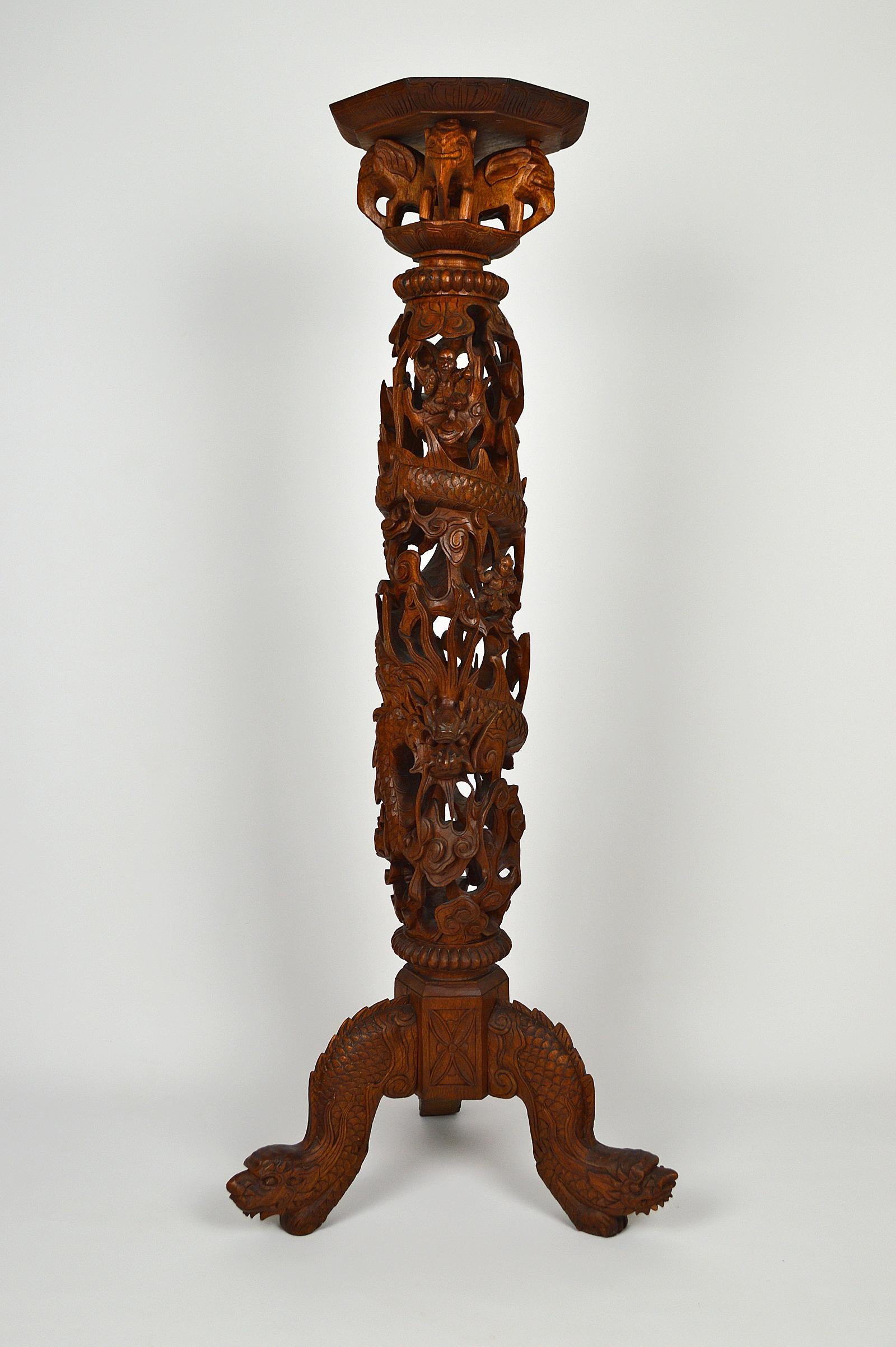 Superb Asian high pedestal table in solid wood richly carved. 

The tripod base is composed of 3 heads of dragons / demons.
In the center, a dragon walks on clouds. He is surrounded by 3 small characters, the San Xing (