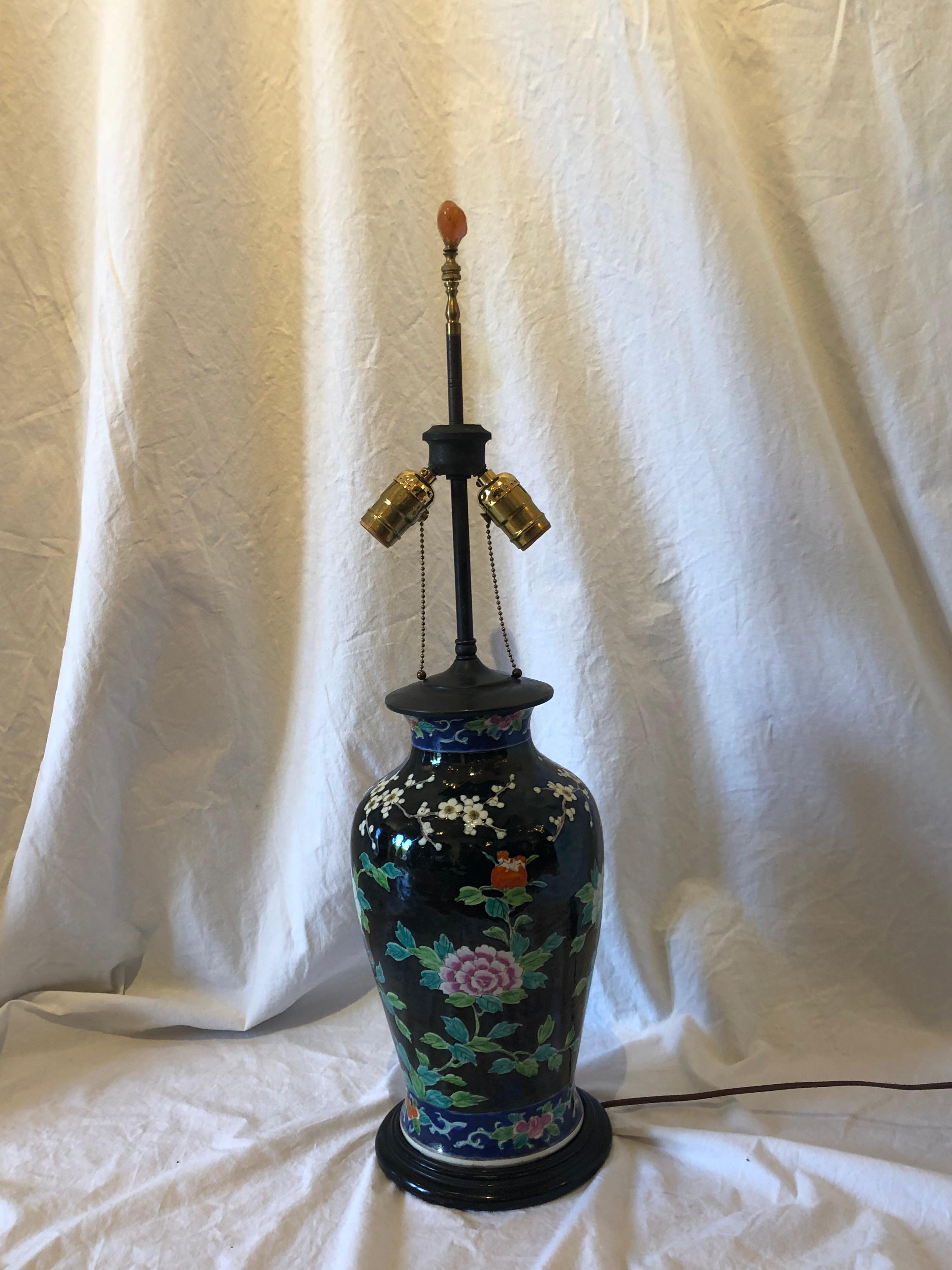 Asian porcelain vase table lamp. Black ground with phoenix bird, cherry blossom and mum motif.

20th century.

Measures: 29