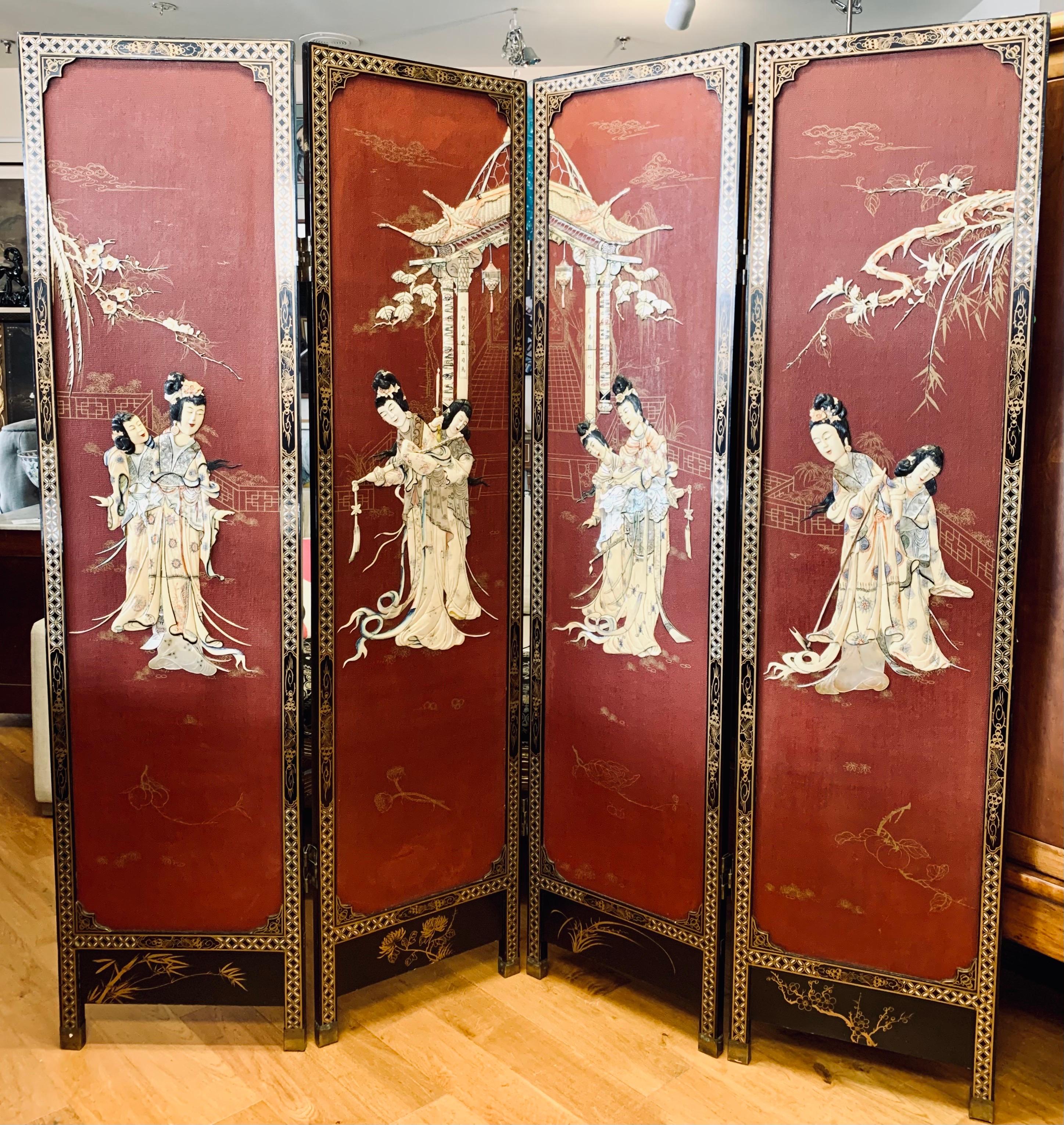 Stunning expandable Chinese red four panel carved room divider/screen with carved hardstone raised figures. The back is black lacquer and is handpainted with branches and flowers. Each panel measures 18