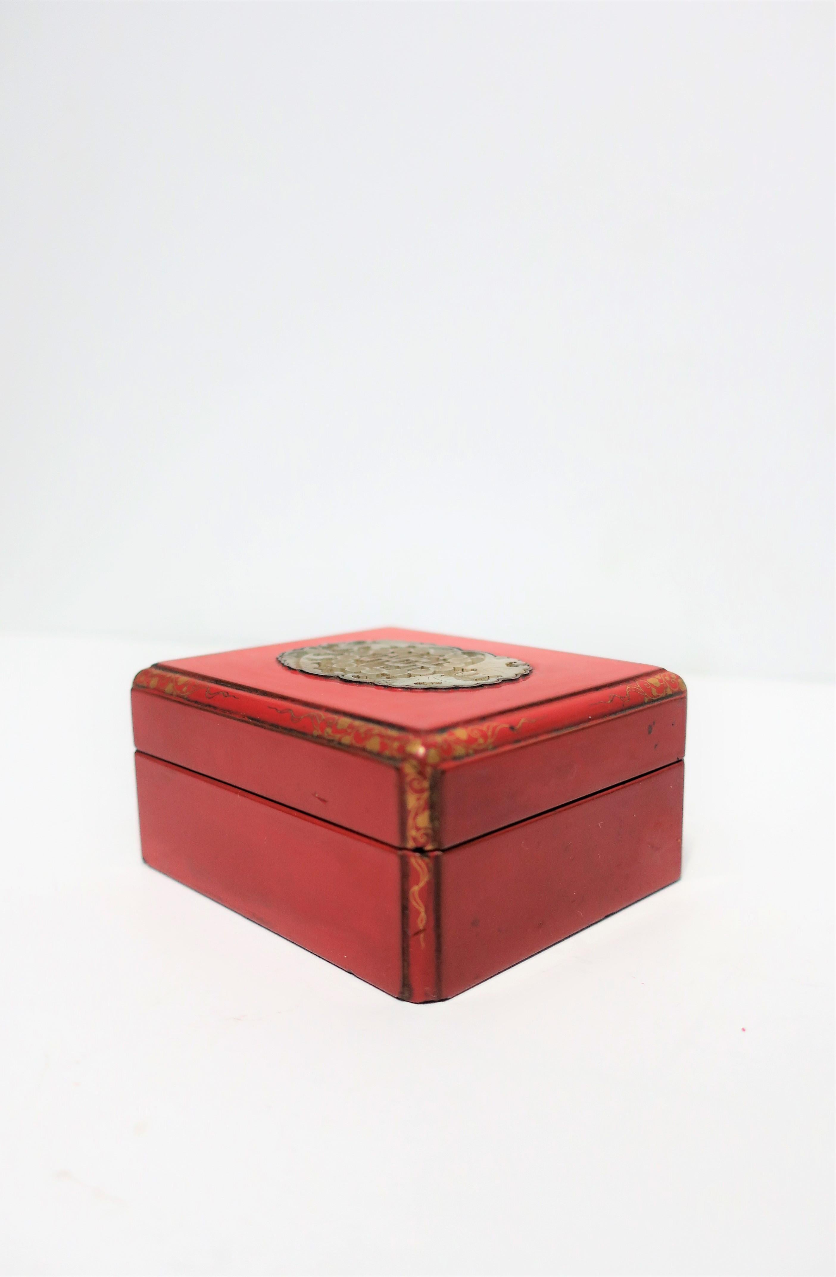 An Asian red burgundy lacquered box with Chinese white jade top and gold detail corners, Art Deco period, Japan. A beautiful square decorative box for jewelry or other small items, in a red burgundy/Ox blood lacquered wood and an inset Chinese 19th
