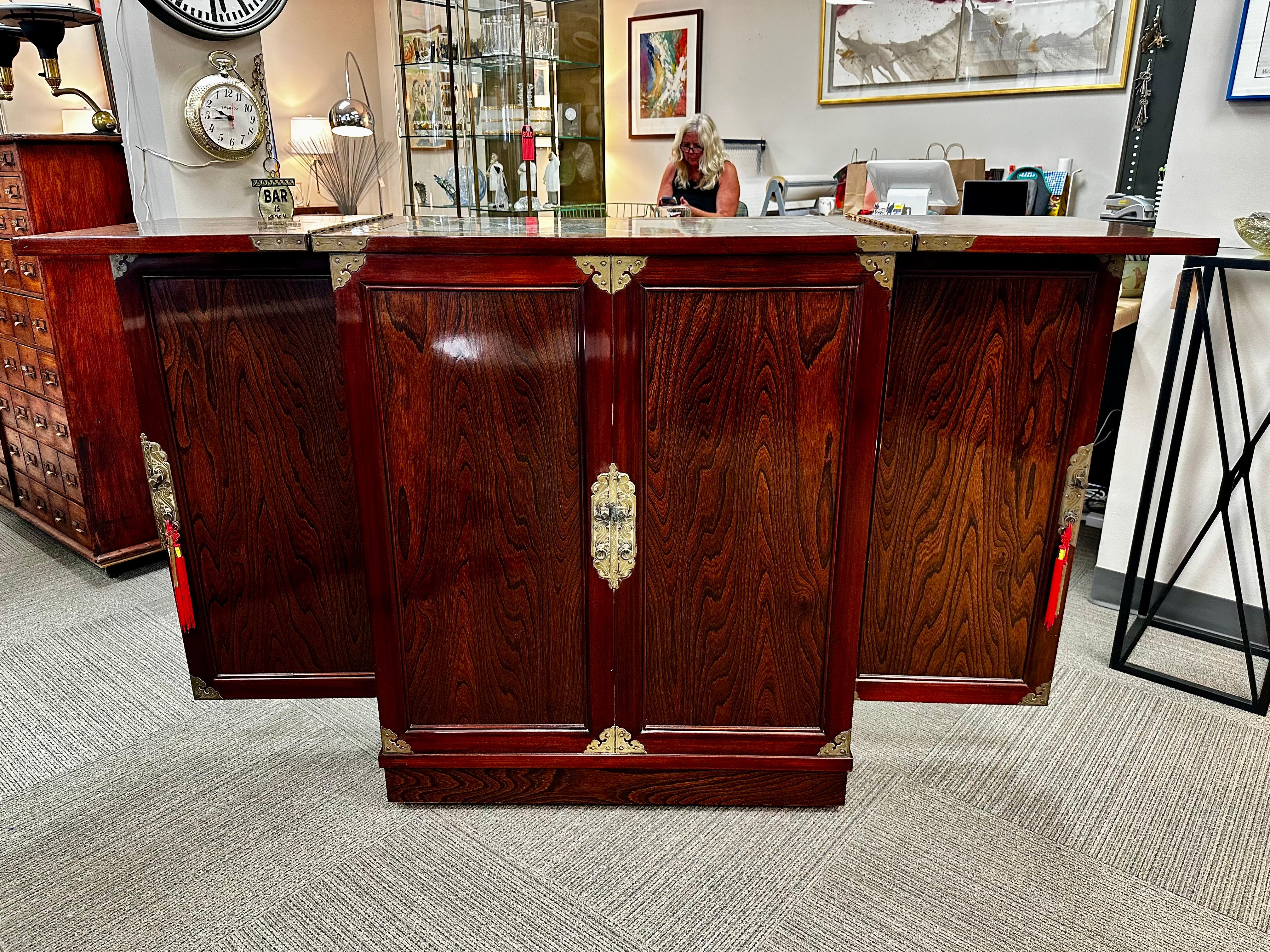 Bar double face asiatique rosewood

Ce superbe bar à sec en bois de rose sur roulettes est le fruit d'un travail d'orfèvre. Le bois de rose est magnifiquement grainé et poli jusqu'à ce qu'il soit brillant. L'avant et l'arrière du bar semblent