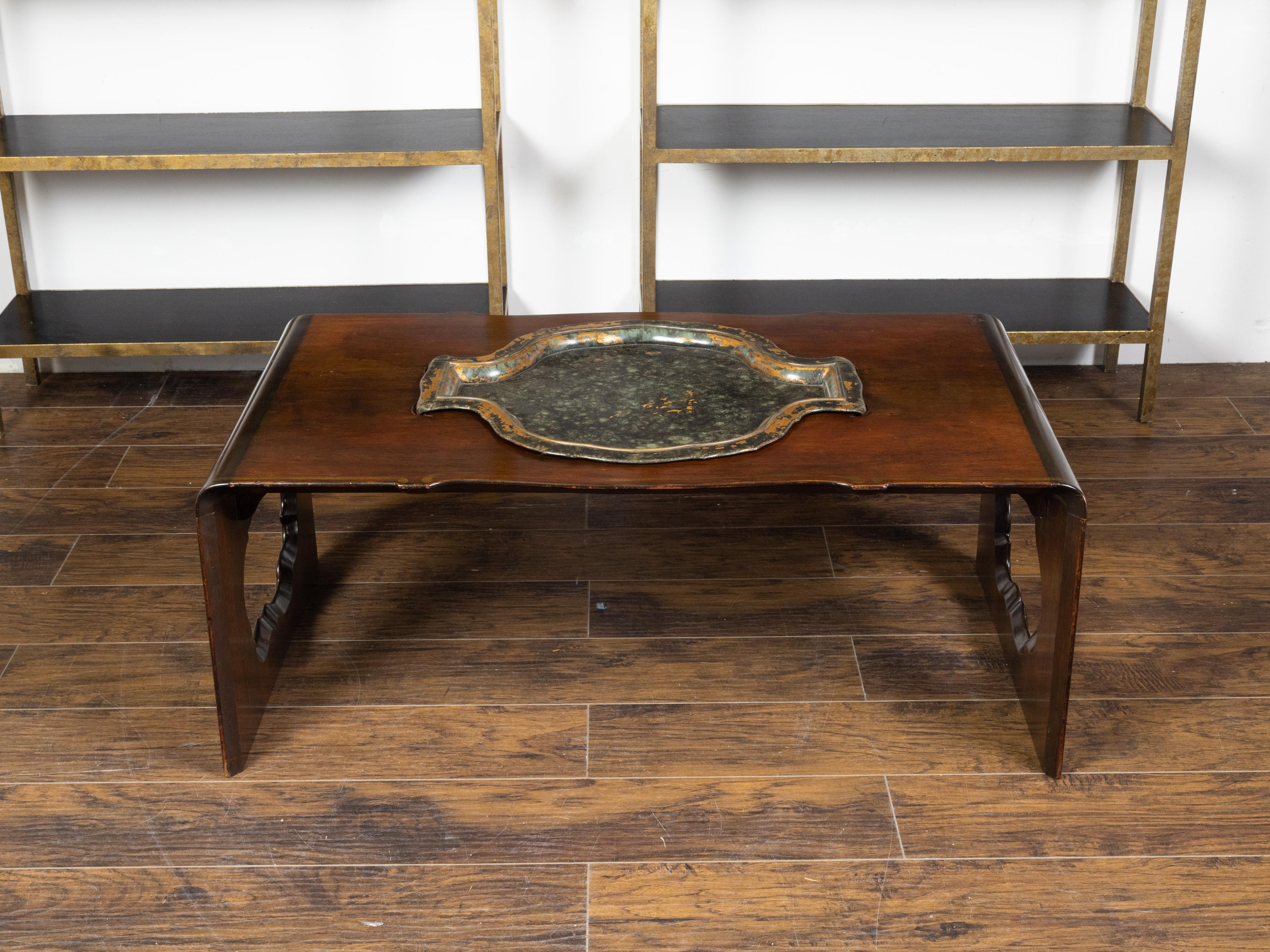 A vintage Asian rosewood waterfall coffee table from the mid 20th century, with removable tray and pierced sides. Created during the midcentury period, this rosewood coffee table features a rectangular top with removable tray in its center, falling