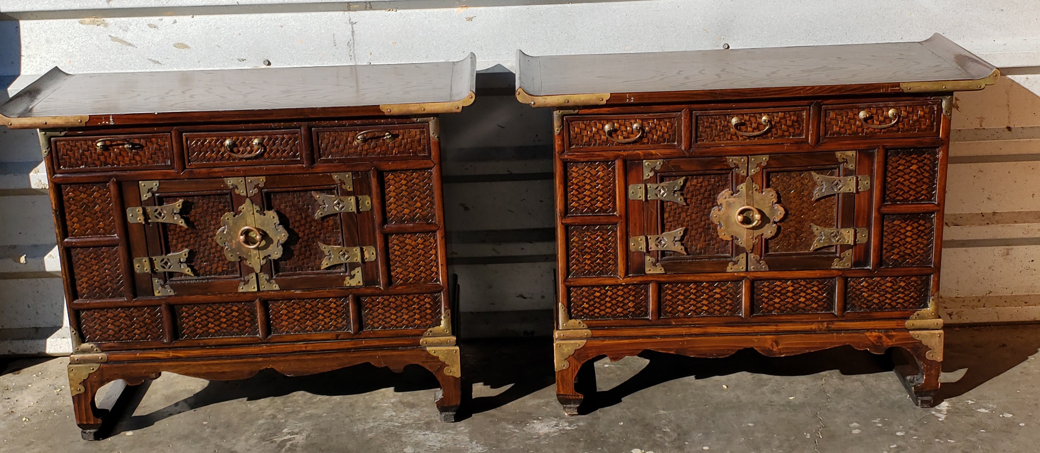 A Pair of Antique Asian scholar's chests /side tables configured with 3 upper drawers and lower cabinet compartments. Beautifully appointed with striking drop pulls and wicker face drawers on top as well as elegant start medallion hasp and strap