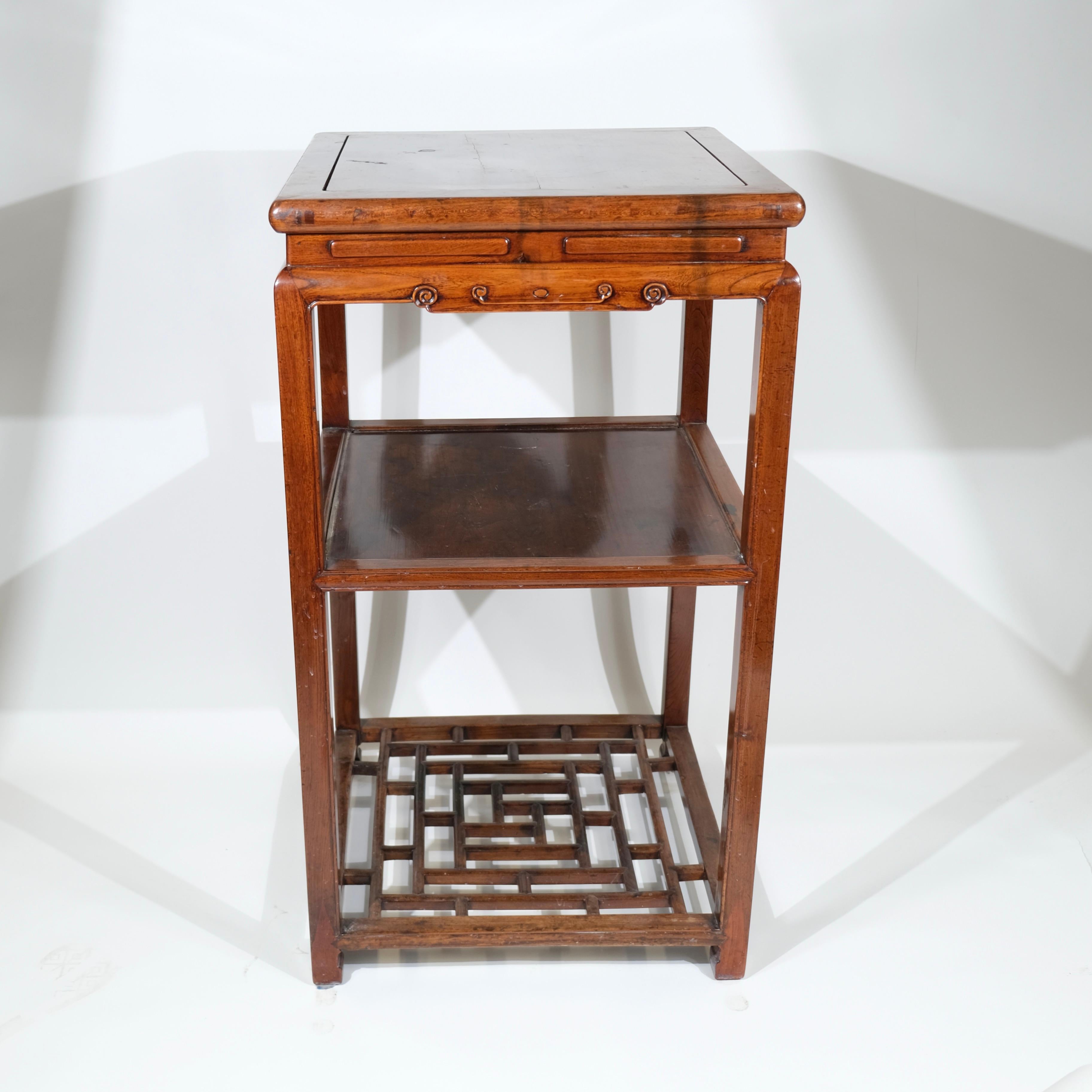Il s'agit d'une table haute raffinée, probablement d'origine chinoise et datant du début du 20e siècle. La table présente un savoir-faire élégant avec des lignes épurées et une structure ouverte, une marque de fabrique du design chinois
