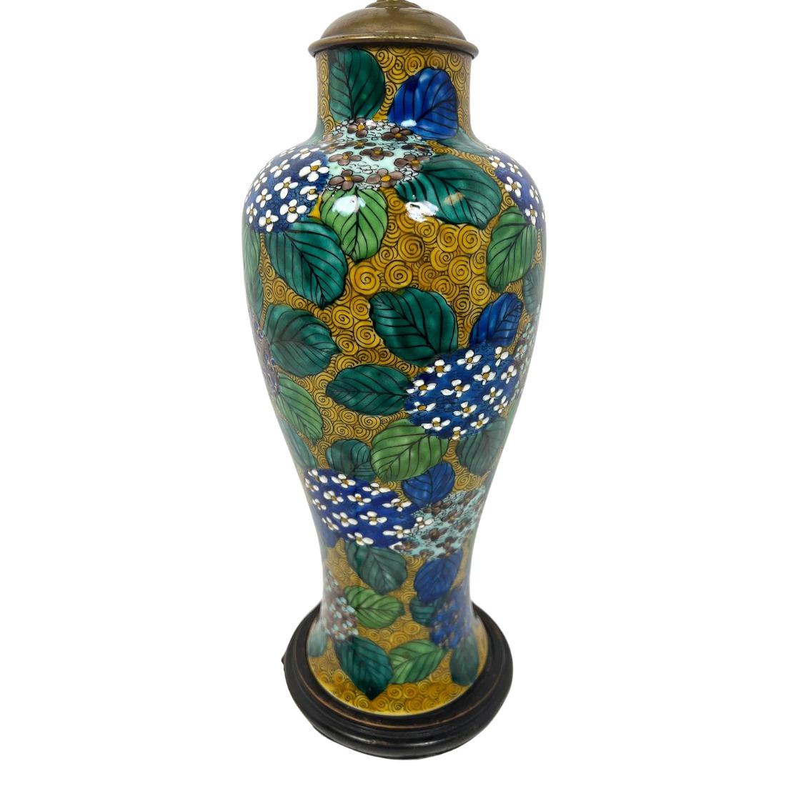 Die elegante Porzellan-Tischlampe im asiatischen Stil zeigt ein wunderschön handgemaltes Hortensienmotiv in Blau- und Grüntönen vor einem schwarz-goldenen Hintergrund. Das reichhaltige, mehrschichtige Design verleiht Tiefe und Raffinesse, während