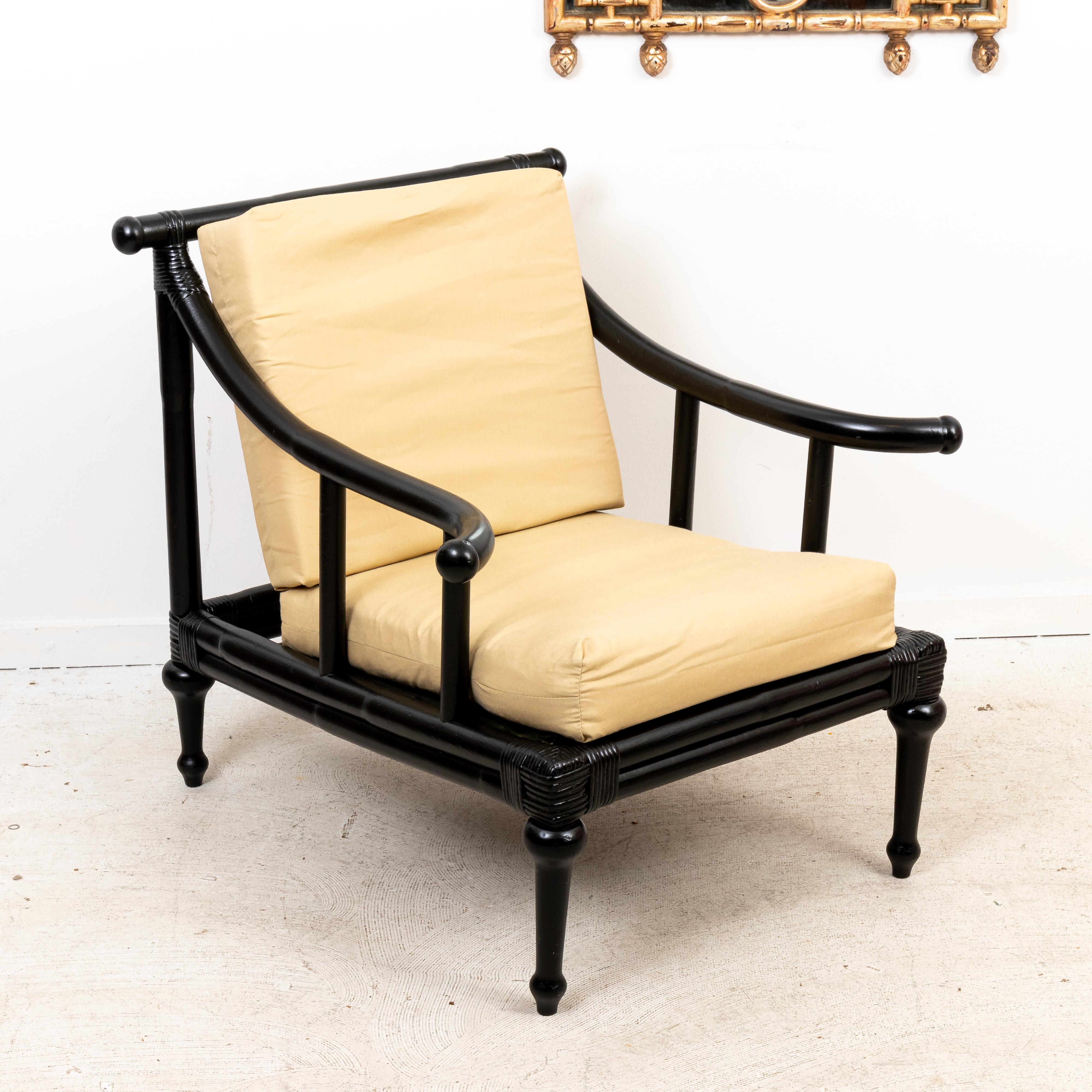 Circa mid-20th century Asian style rattan lounge chair and ottoman with black painted finish on ball turned legs. Made in the United States. Please note of wear consistent with age. The cushions are only stapled closed, they may need to be