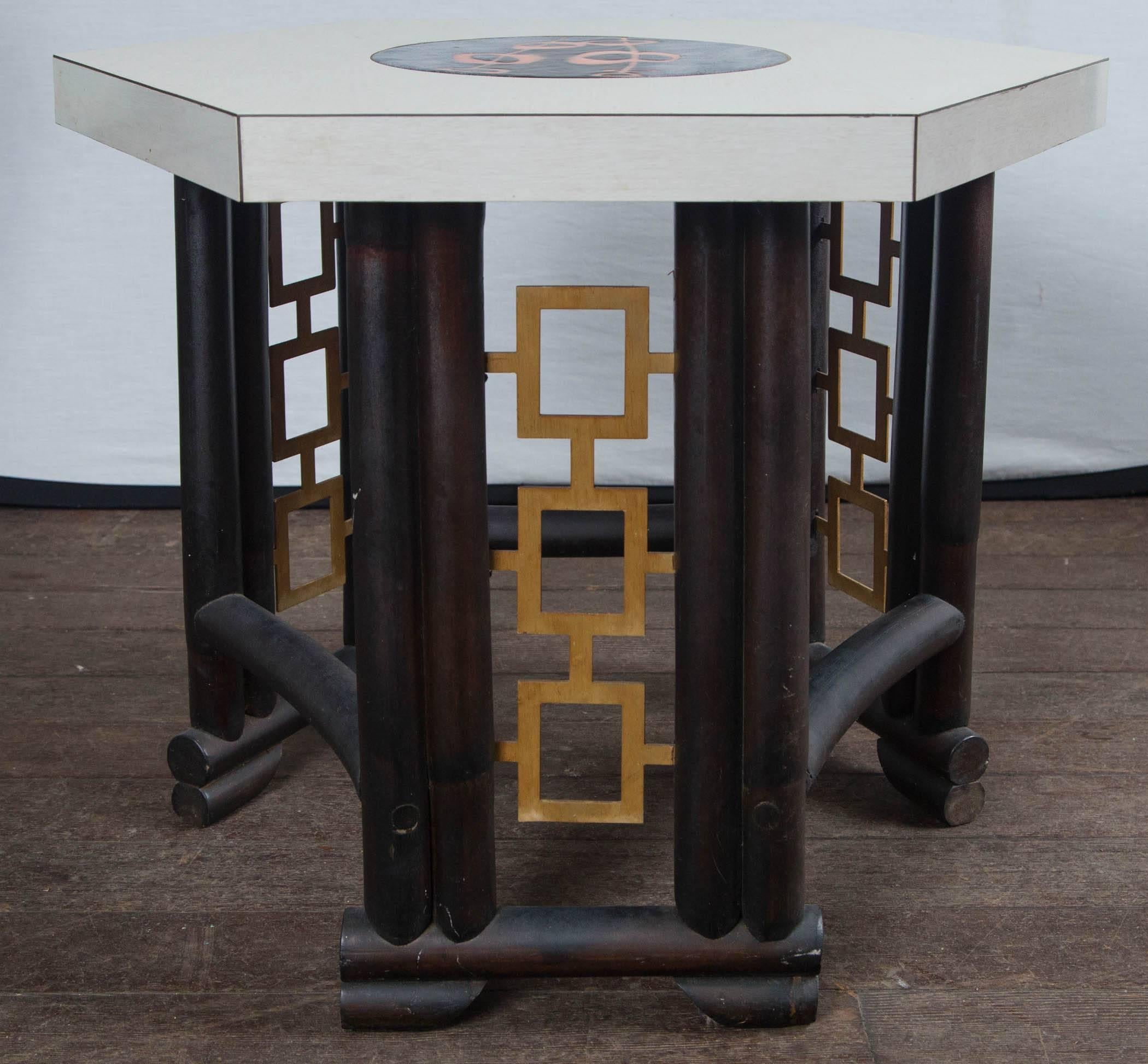 Custom-made Asian, bamboo style wood table, laminate top with inlaid round enameled piece in center. Geometric gilt metal design on base. Very chic!
