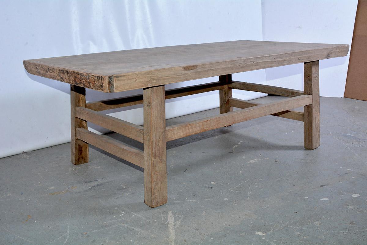 The rustic Asian coffee table is constructed with a teak wood plank top held by breadboard ends. The table is secured with pegged legs and stretchers - doubled at the ends. Ready to appear in an informal setting or on a porch. Great proportions.
 