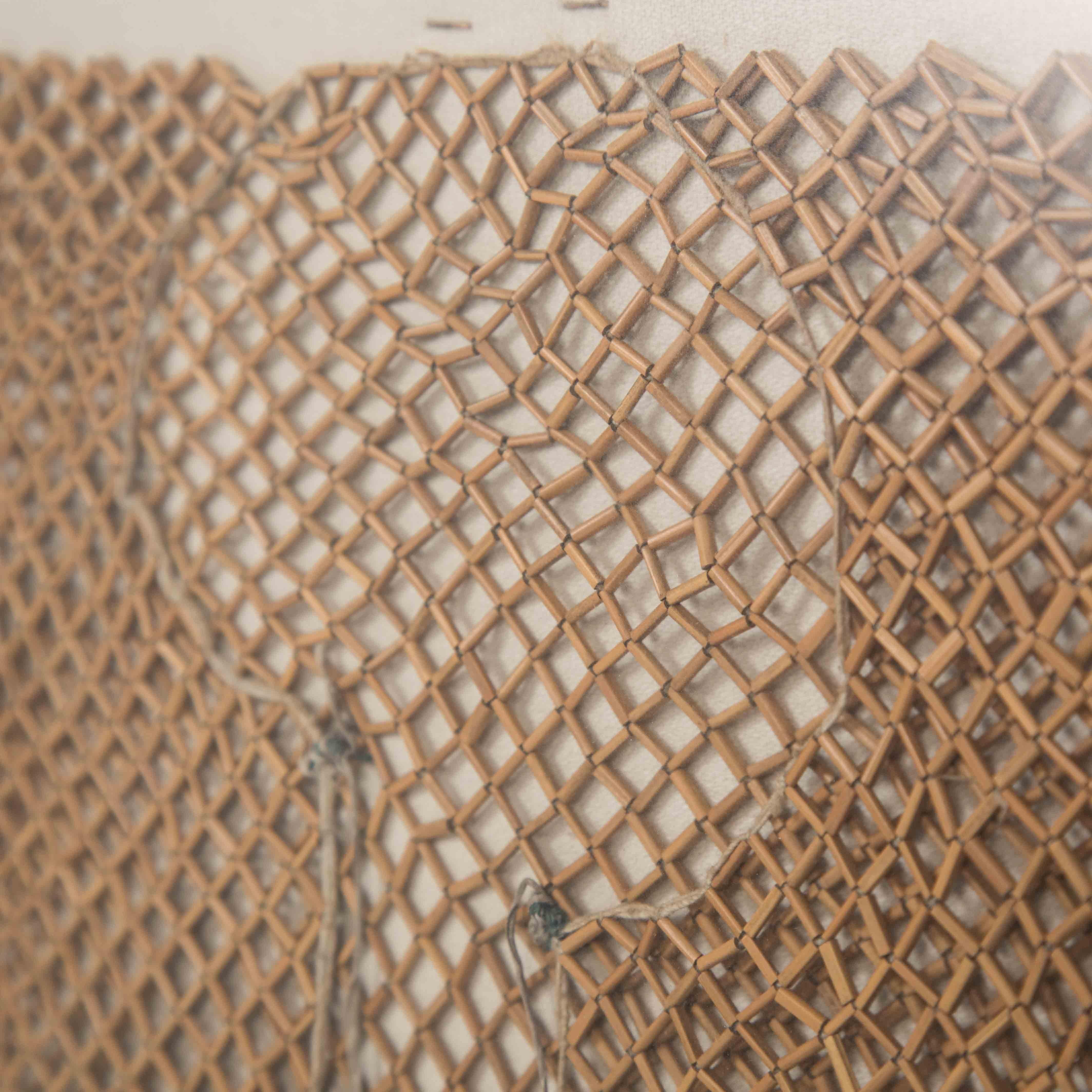 Asiatisches Textilbild einer geknüpften Bambusjacke auf Leinen, Myanmar 1900-1920

Das fein zusammengesetzte Objekt aus kleinen Bambusstäben ist zu einer losen Jacke geworden. 
Die Ränder sind gesäumt und mit einer Leinenschnur gesichert.
An den