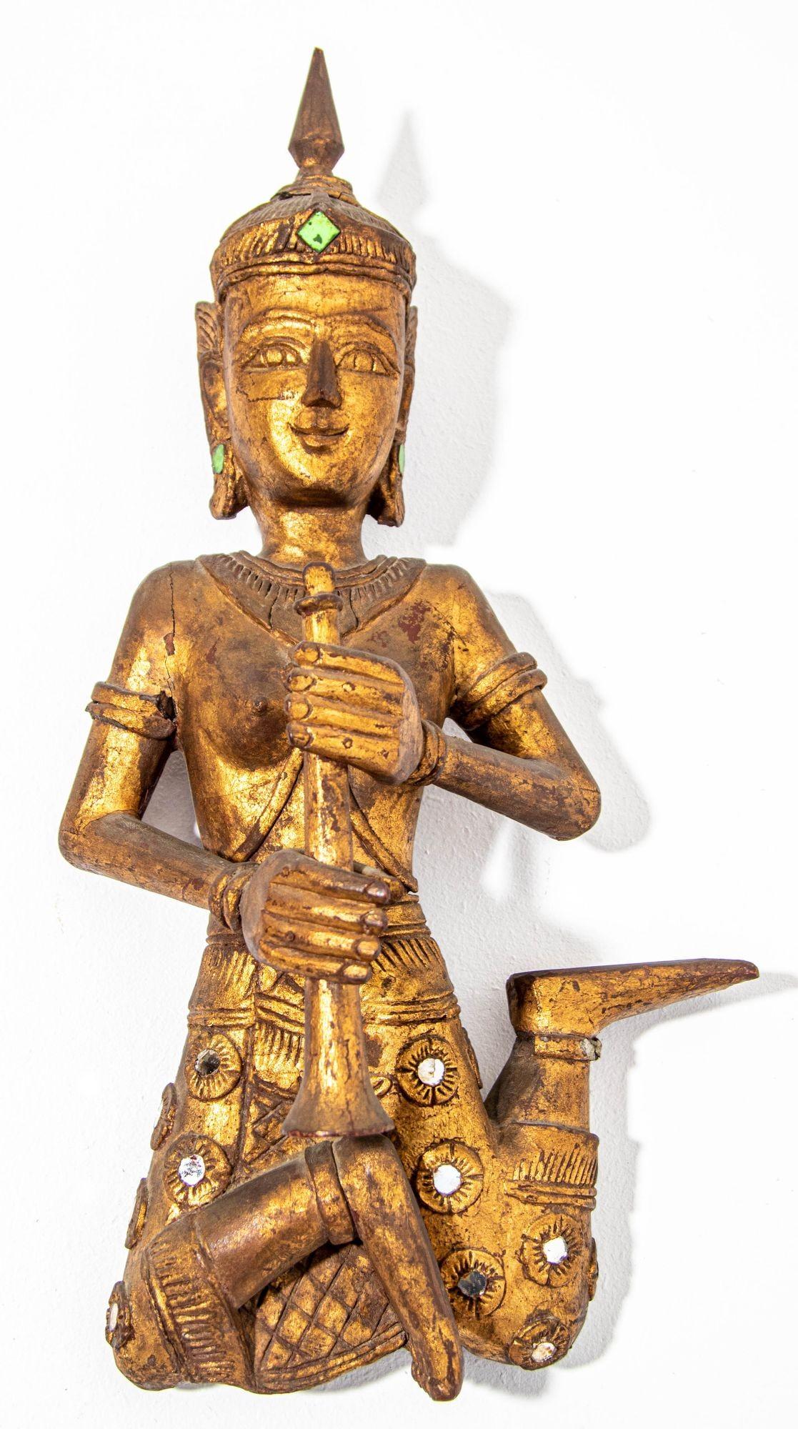 Conjunto de 2 antiguas figuras asiáticas tailandesas de músicos siameses, bellamente talladas a mano en madera.
Grandes y pesadas esculturas asiáticas de madera dorada que representan figuras de ángeles birmanos tailandeses tocando instrumentos de