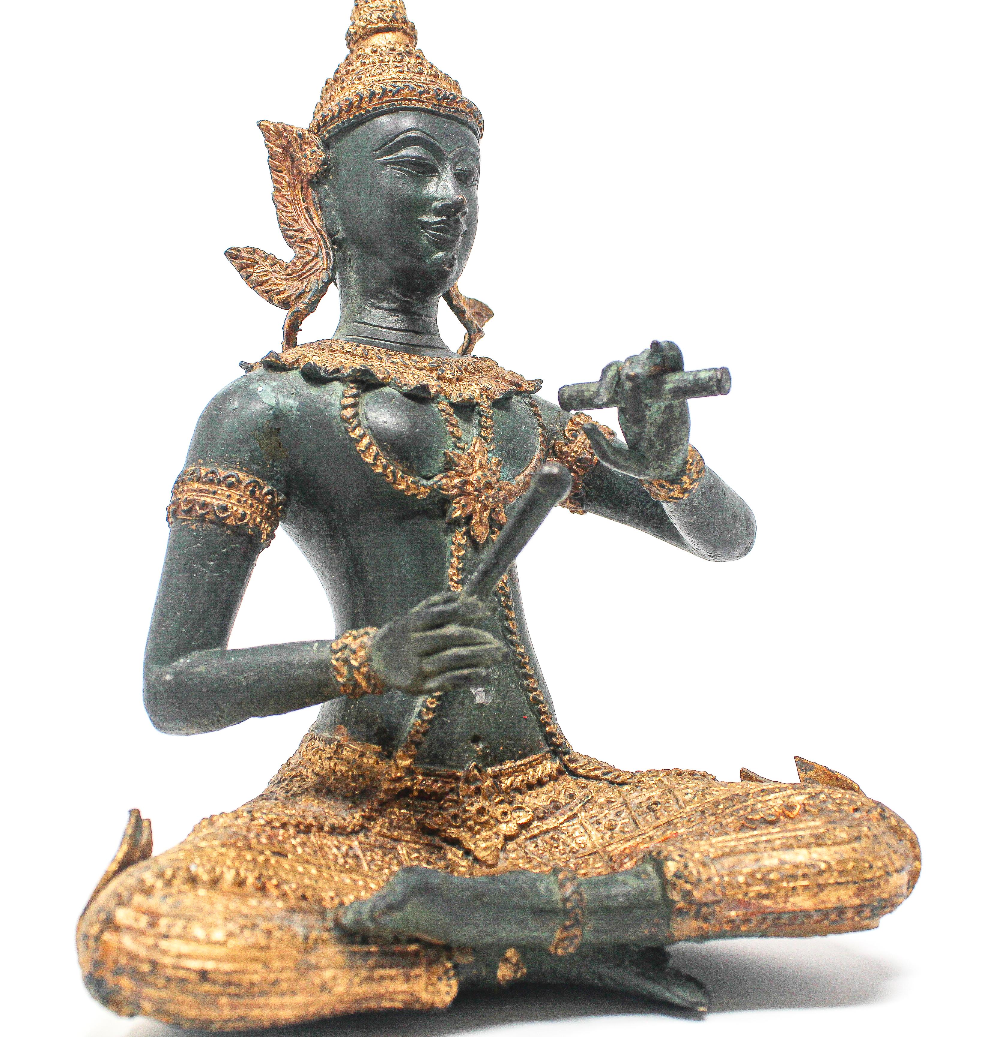 Asian gilt bronze statue of Prince Pra Apai Manee playing a traditional Asian instrument.
Intricate gilt bronze hand cast Buddha figure in dark green with gold leaf detailing, the ceremonial costume and the jewelry are adorned with gold