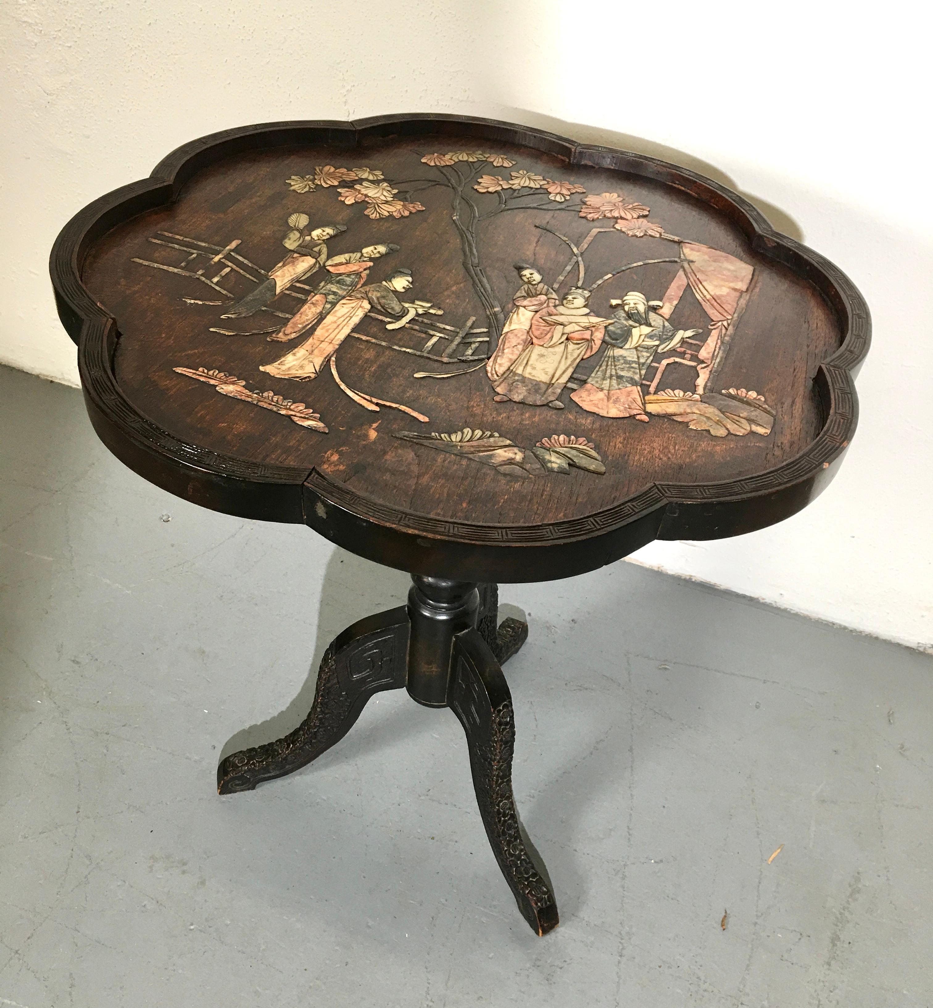 Asian tilt top table with decoration on top.