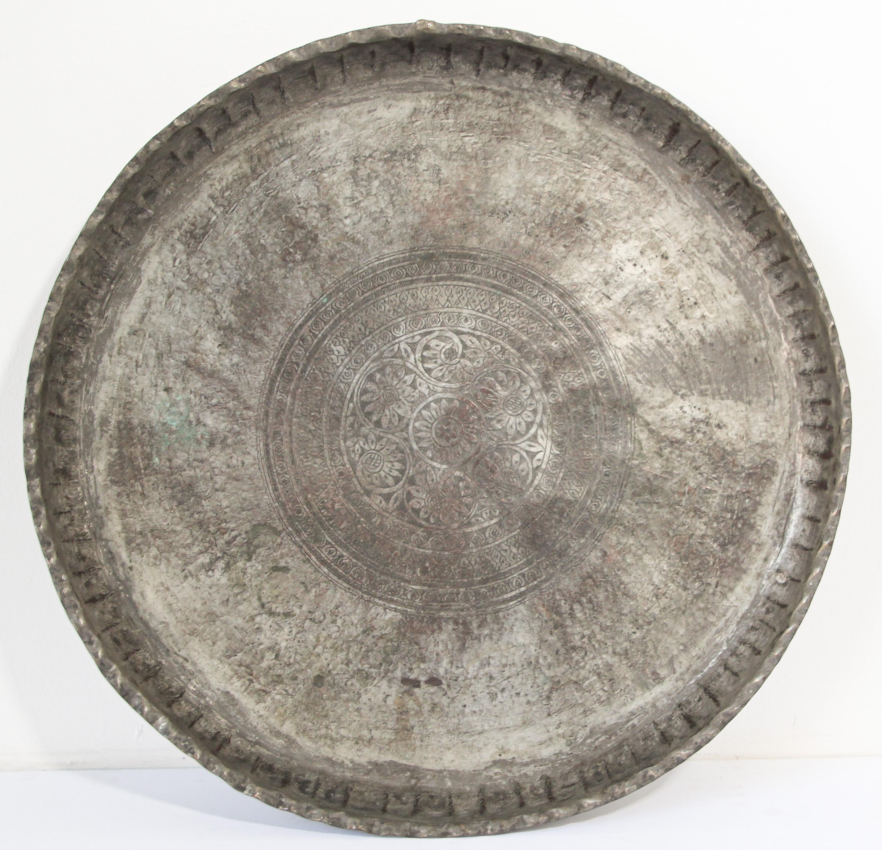 A large-scale 19th century Moorish Turkish Asian tin copper round tray platter.. 
With deeply scalloped hand-hammered edge, with intricate incised geometric decoration, floral arabesques spiraling from the centre,
Antique Turkish tinned copper