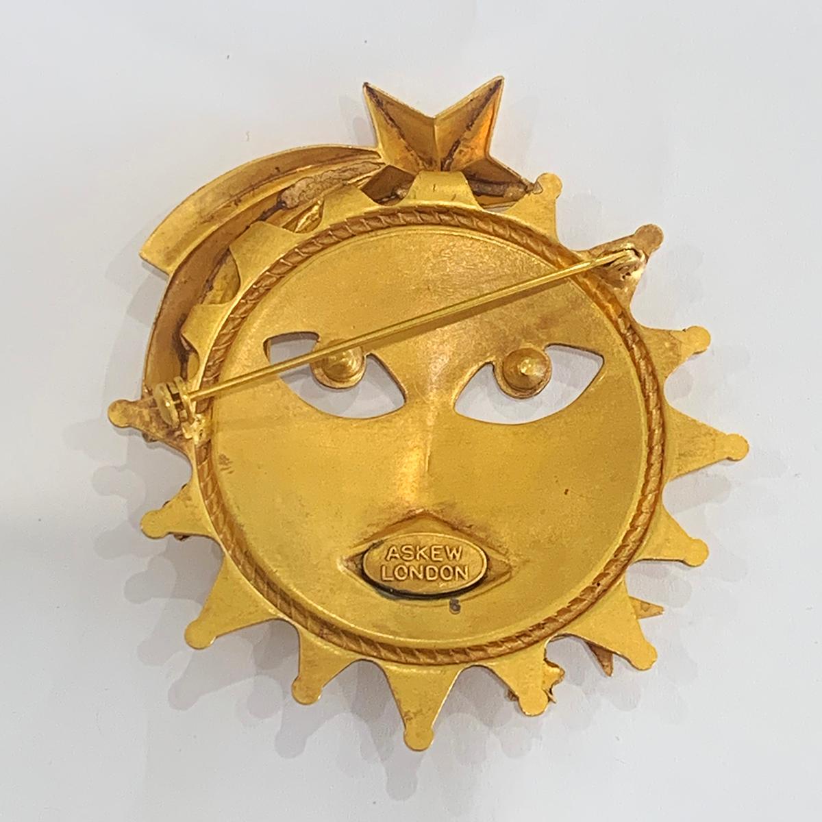 Large Sun Brooch or pin by “Askew of London” with “Sun Face” as the main design. With a “Shooting Star” and other stars highlighted with diamantes. Hallmarked to the rear, “ASKEW” over “ LONDON” within an ellipse surrounded.  All the metal has 24ct