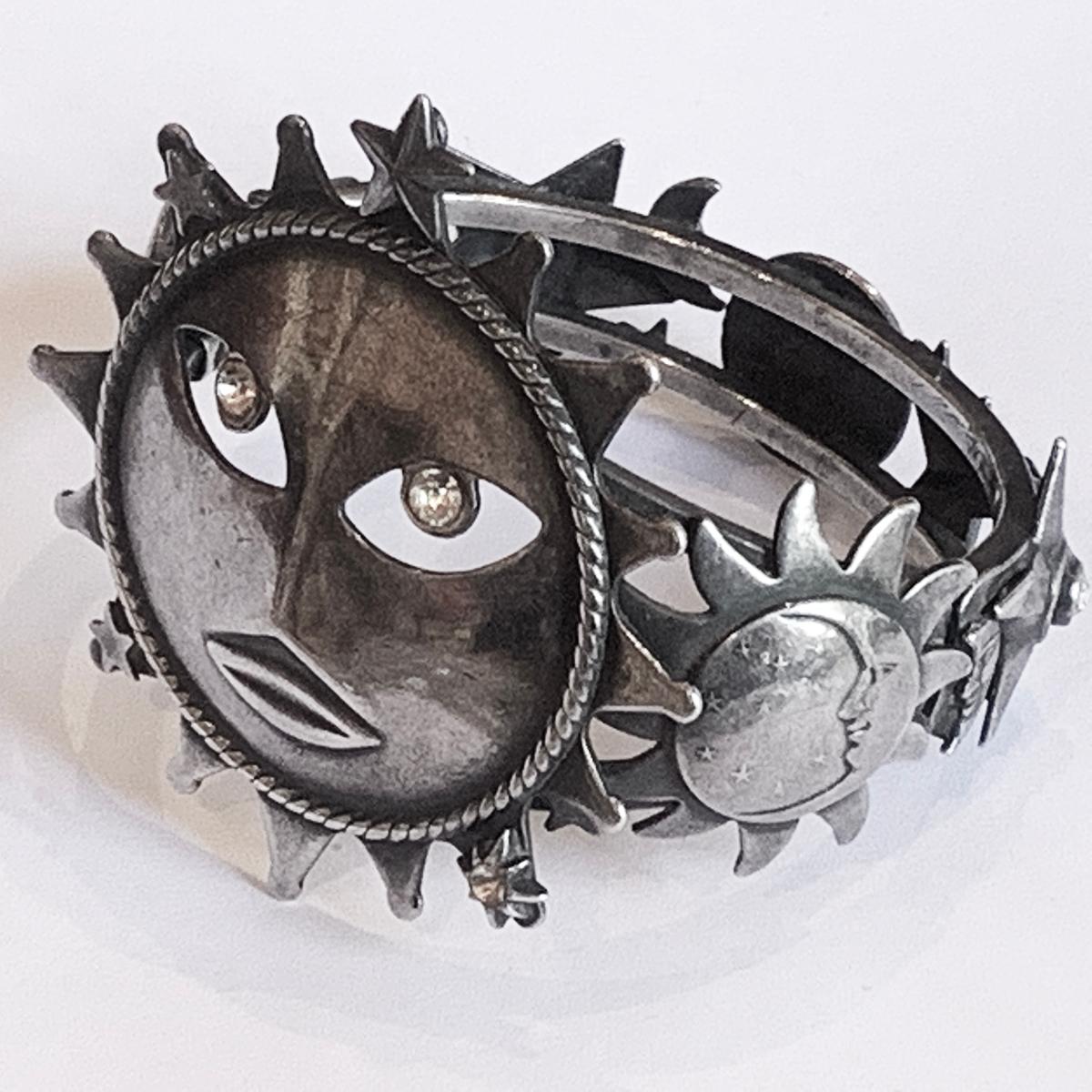 An Askew of London Clamper Bangle, depicting the Full Moon with diamante eyes all in Silver finish. The sides have New Moon phases, all with faces and , and Stars, all in different sizes and decorated with diamantes. The bangle is typical Art Deco