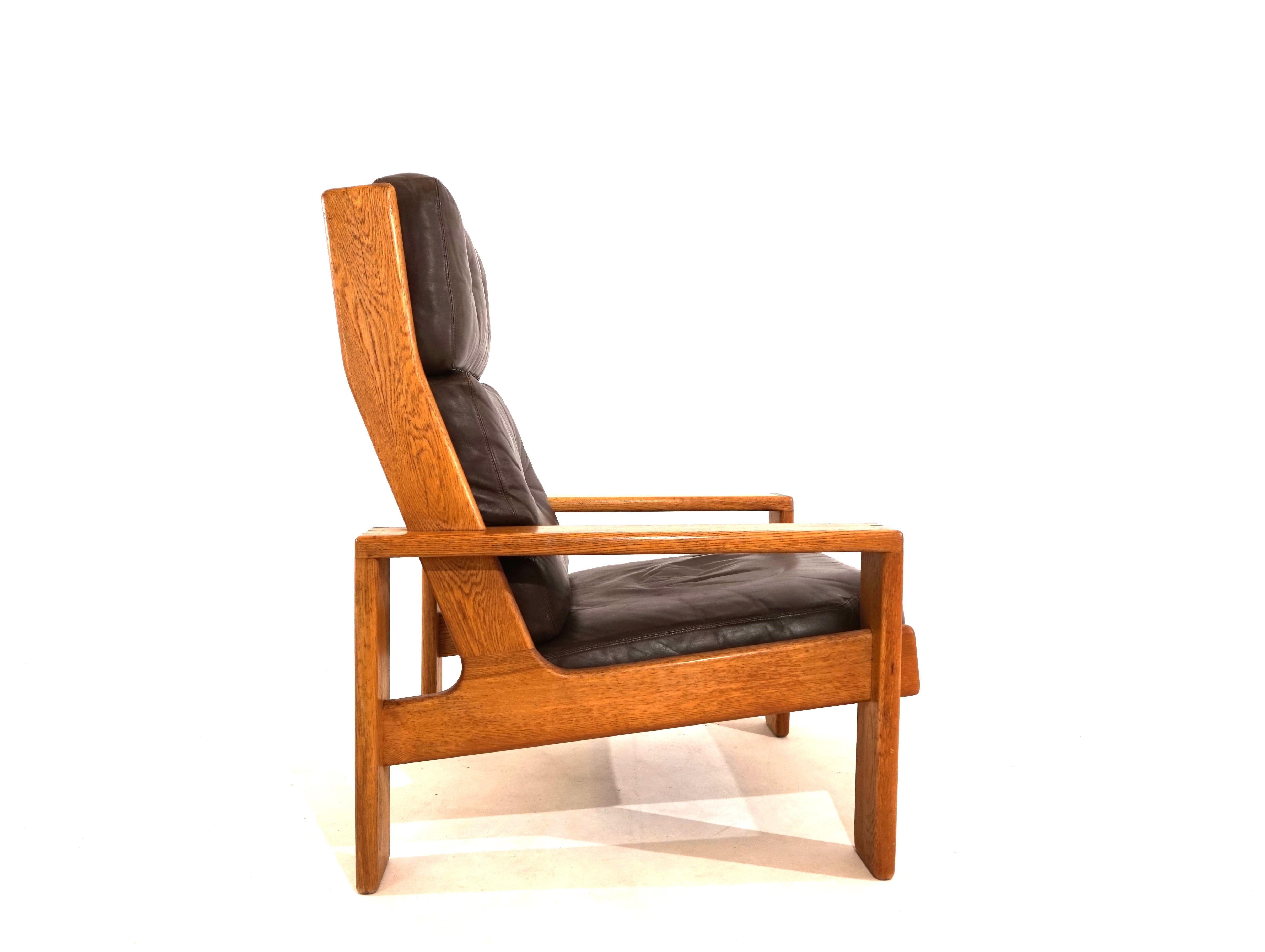This Bonanza armchair from the 1960s comes in the rare high-back version and in dark brown leather with an oak frame. The armchair shows hardly any signs of wear on the leather, the thick leather is soft and supple. The solid oak frame is in