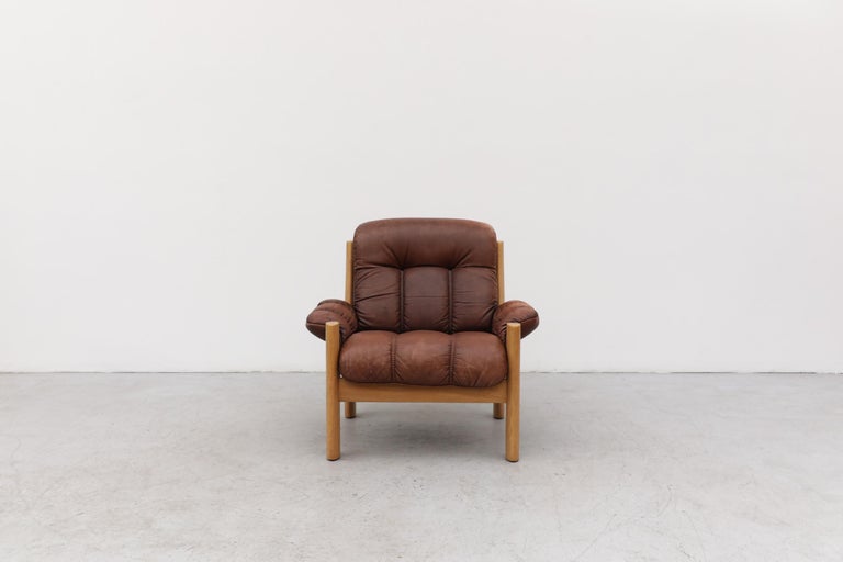 Tufted leather lounge chair with a great patina by Finnish design company, Asko. The leather is in original condition and has some scratching and wear, consistent with its age and use. (LU922428407412 & LU922428407372).