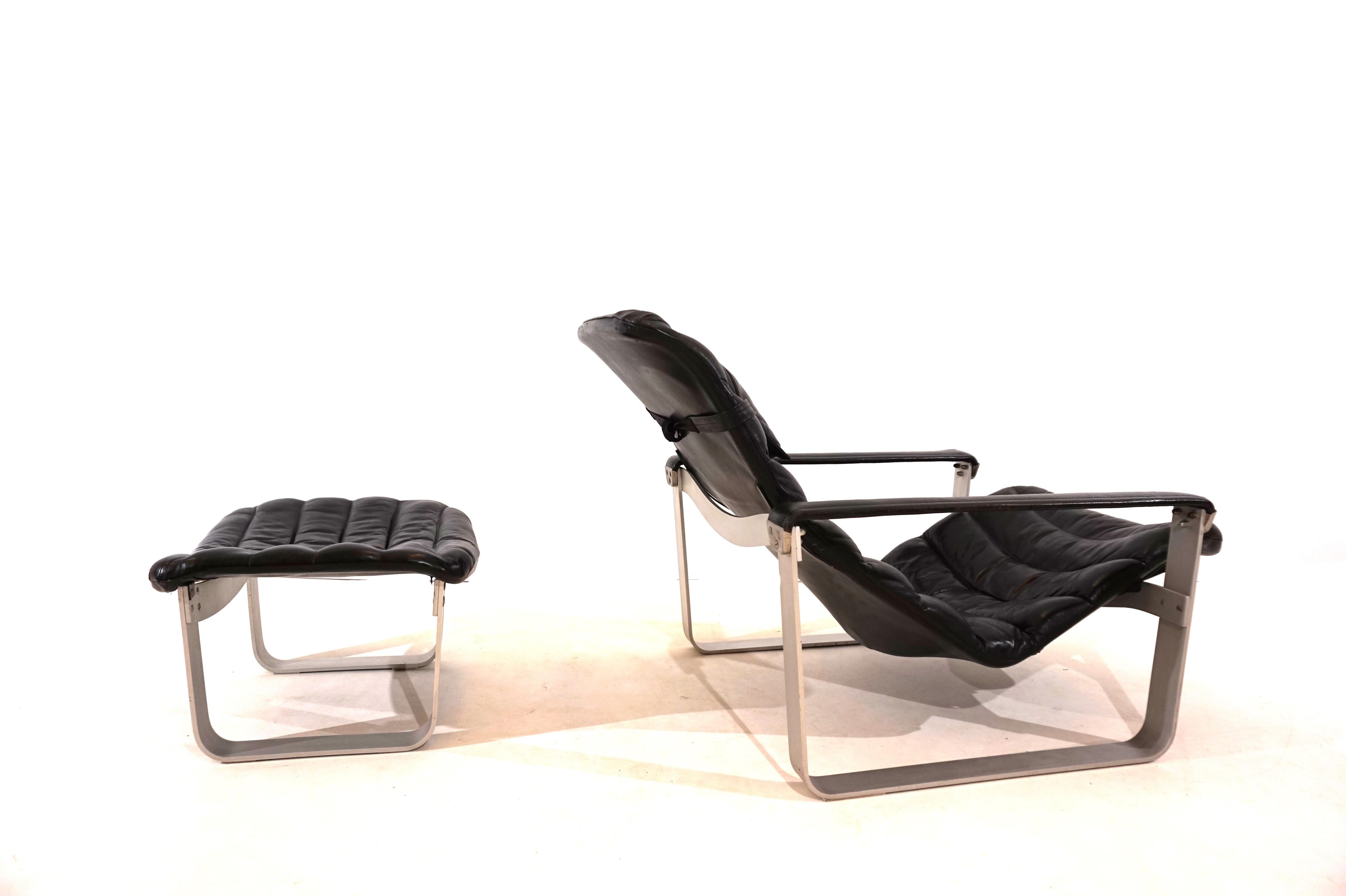 Le fauteuil Asko Pulkka en cuir noir est, comme l'ottoman, en très bon état. Le cuir est souple et intact, les coutures sont toutes en bon état. L'assise du fauteuil repose sur un cadre en aluminium et est réglable de plusieurs façons. Le cadre