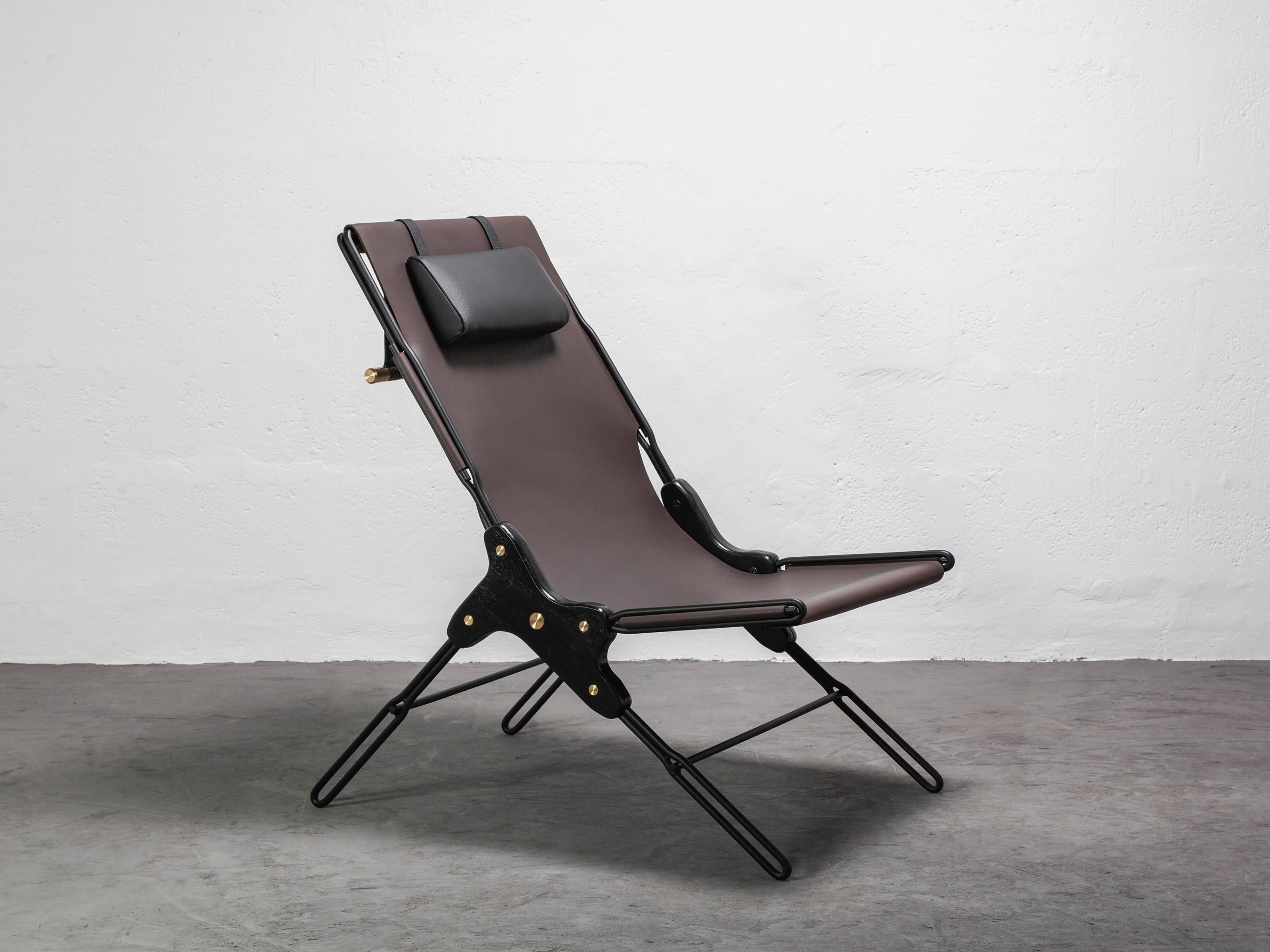 Lounge chair made of black finish steel rod structure and solid colorado wood with a natural oil finish, Ecuadorian cowhide leather seat, and lathed bronze or stainless steel hardware. Available in Olivo, Brown, and Cognac thick leather