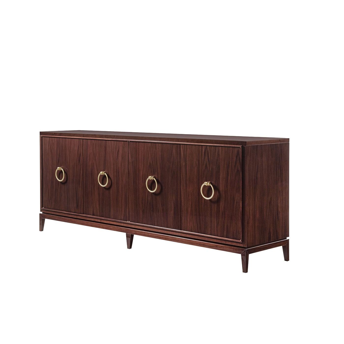 This streamlined sideboard raised on tiny feet provides effective storage with its four doors opening to reveal inner glass shelves. The wooden frame, with base and profile in solid walnut, is finished in glossy tobacco walnut, intense shade only