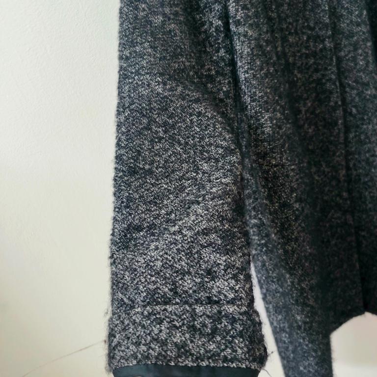 Avvolto nell’eleganza essenziale che contraddistingue Aspesi sin dagli anni ’70, questo cappotto in lana bouclé grigio mélange – taglia 44 IT – incarna perfettamente l’idea di “lusso silenzioso” del marchio milanese. La linea è morbida e fluida, con