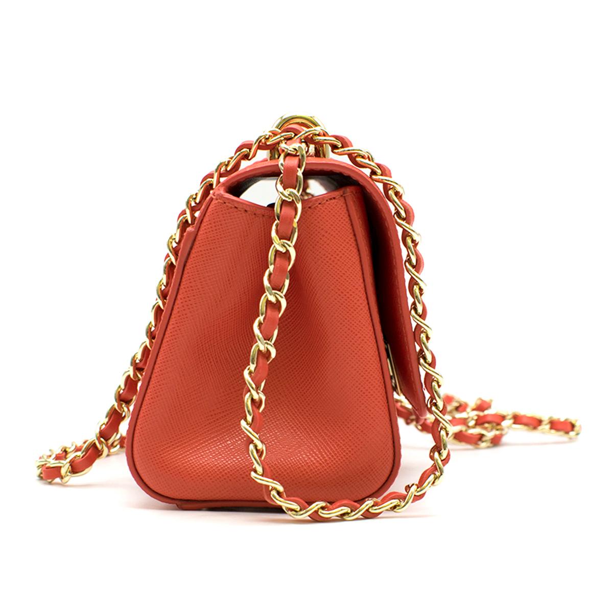 Aspinal of London Micro Lottie Bag 

- Coral leather micro bag
- Signature letterbox lock closure
- Leather plaited metal chain for shoulder and cross-body styling
- Grosgrain lined interior
- Interior patch pocket
- Protective base feet
- Signature