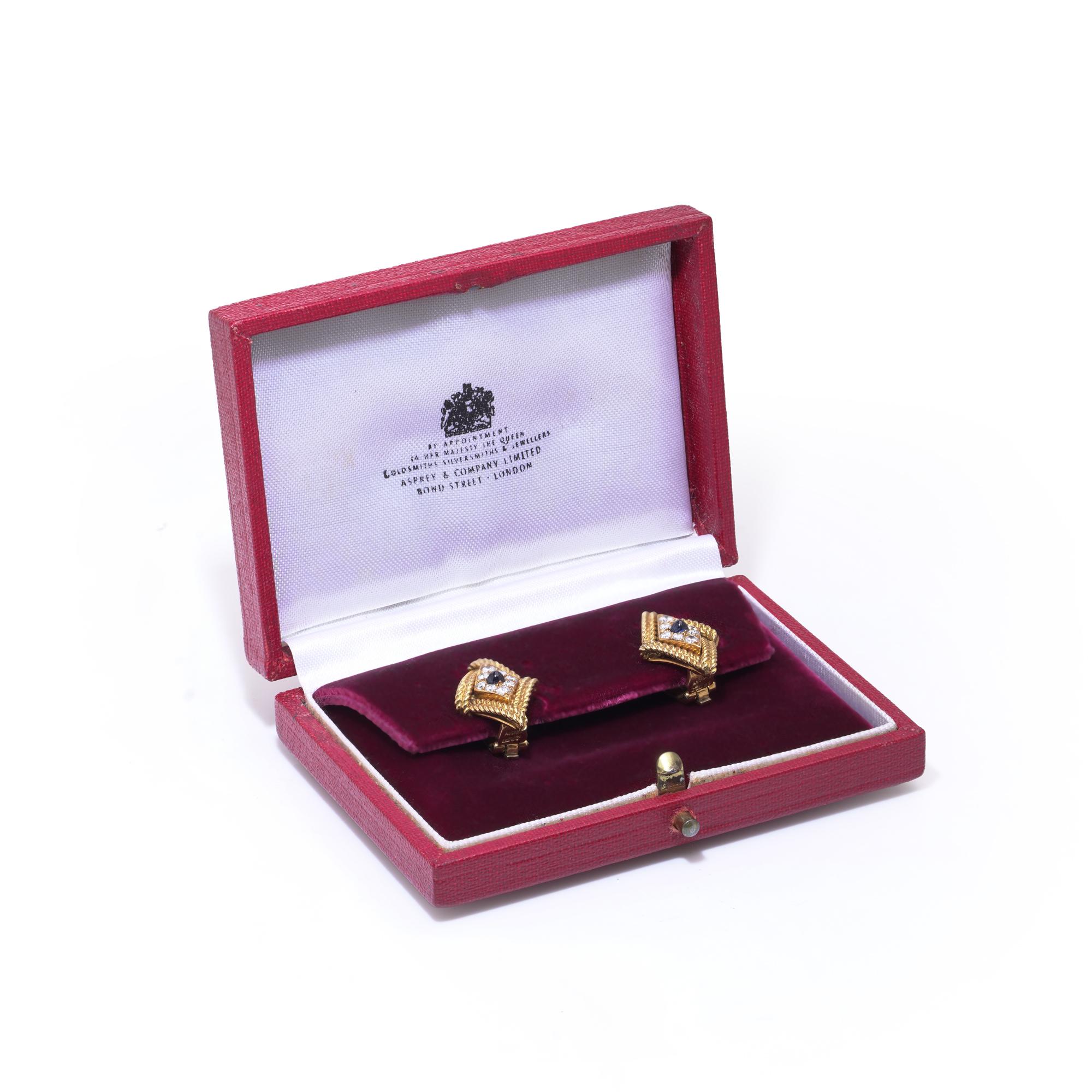 Boucles d'oreilles à pince en or 18kt saphir et diamant d'Asprey - boîte d'origine
Circa 1970's

Une paire sophistiquée de boucles d'oreilles à pince Asprey en or jaune 18kt, présentant un saphir central de taille ronde entouré de huit diamants