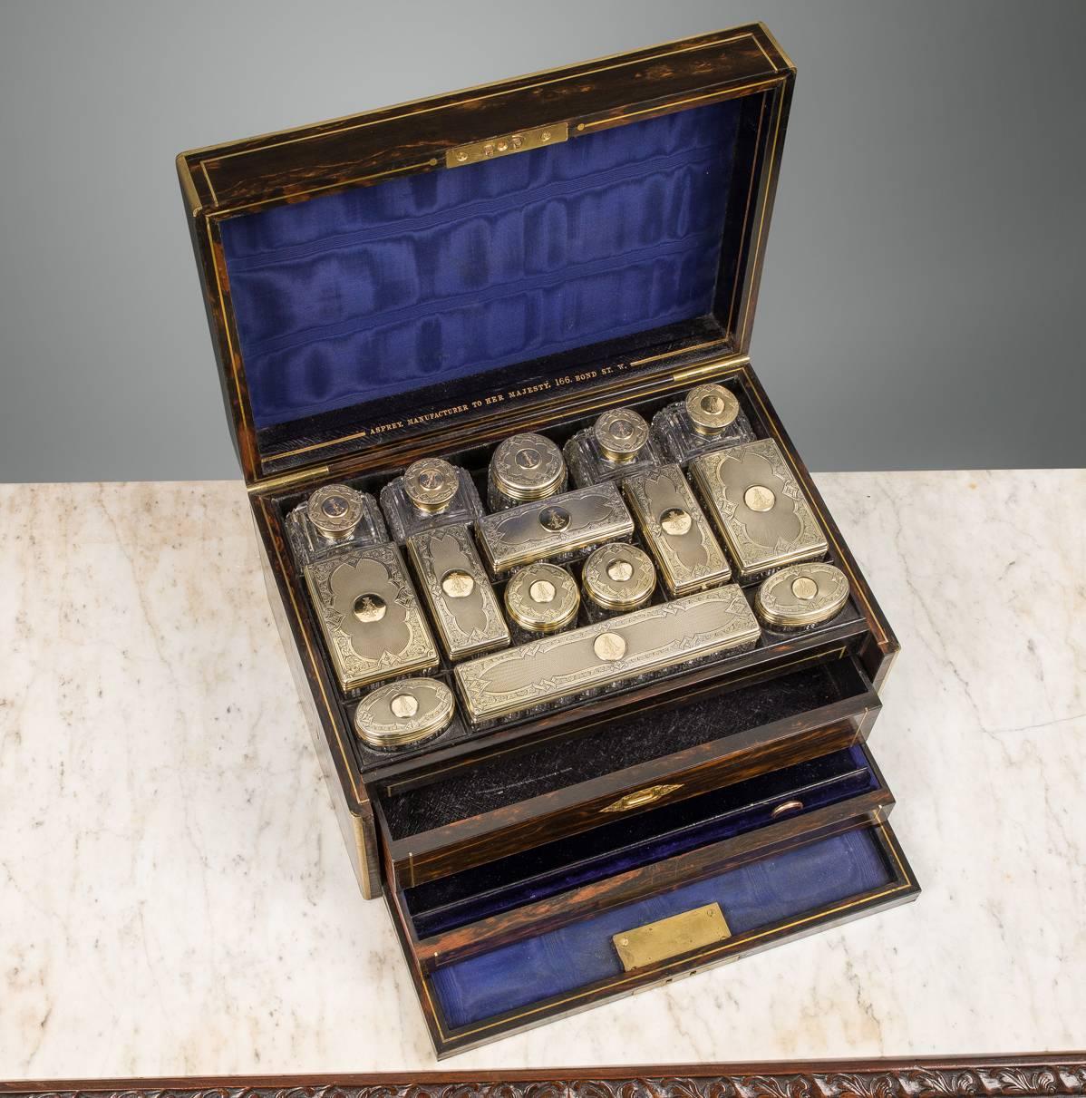 A traveling set comprising fifteen glass containers of various function and size all mounted with silver gilt engraved tops, each with the co-joined initials, A and I, lined and filled in leather for compartments. The silver fully marked Abraham